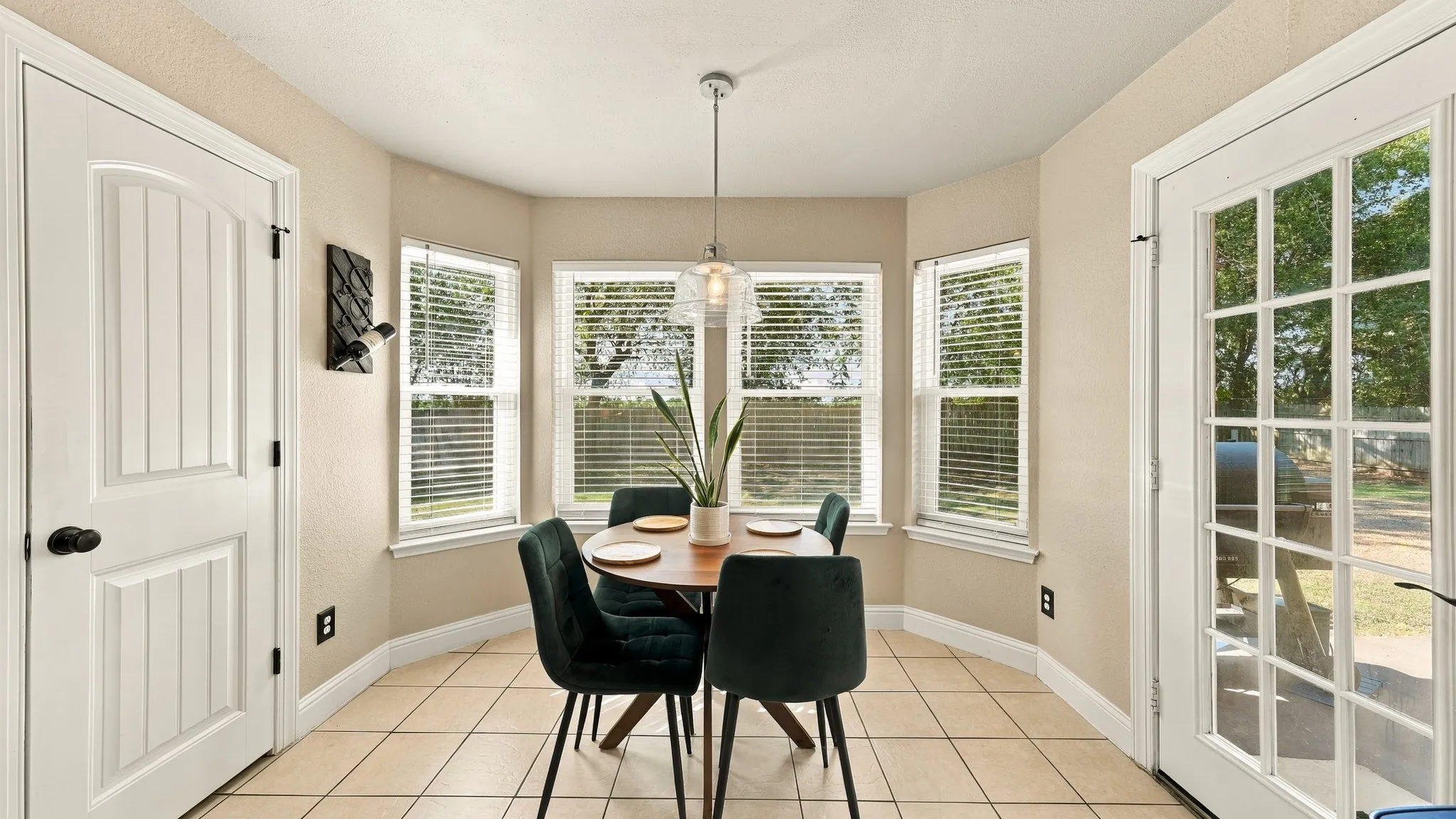 Bay window with multiple glass panes, ceramic tile flooring, and a glass-paned exterior door