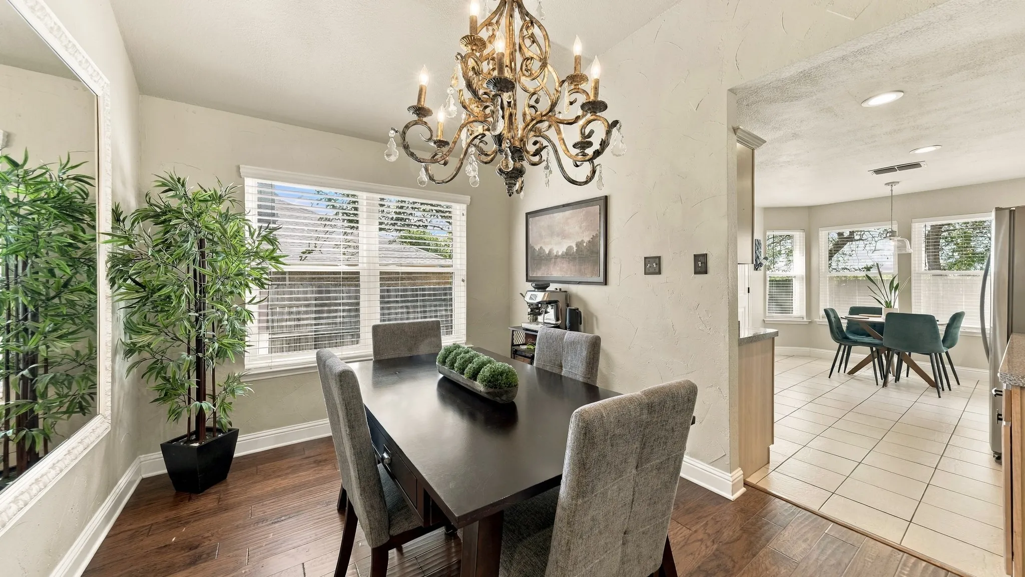 Dining area featuring a decorative chandelier, wood-finish flooring, and a large window