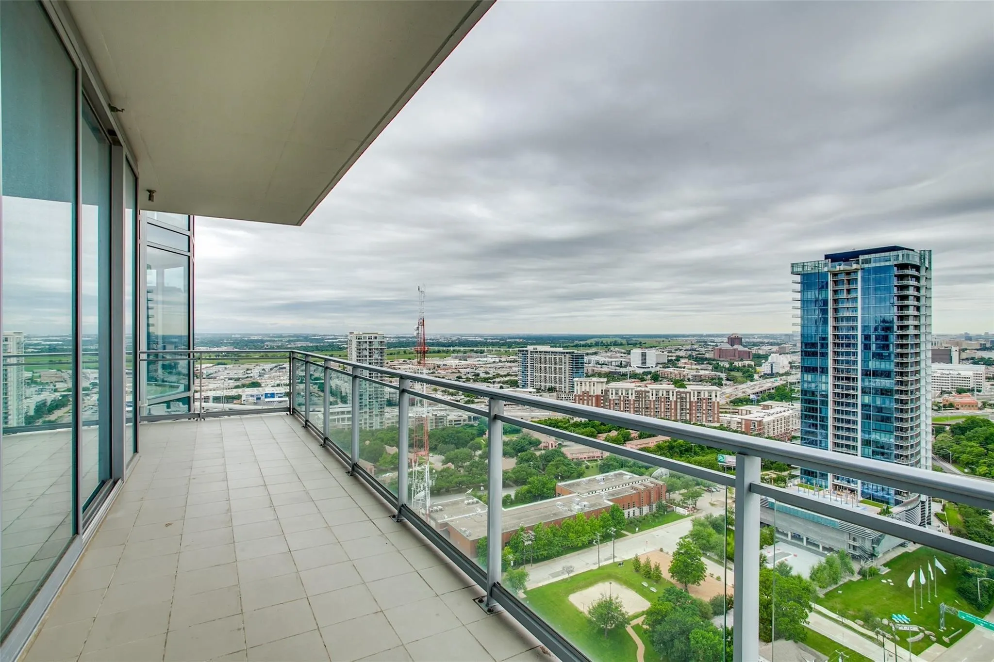 Balcony featuring tiled flooring and a glass panel railing