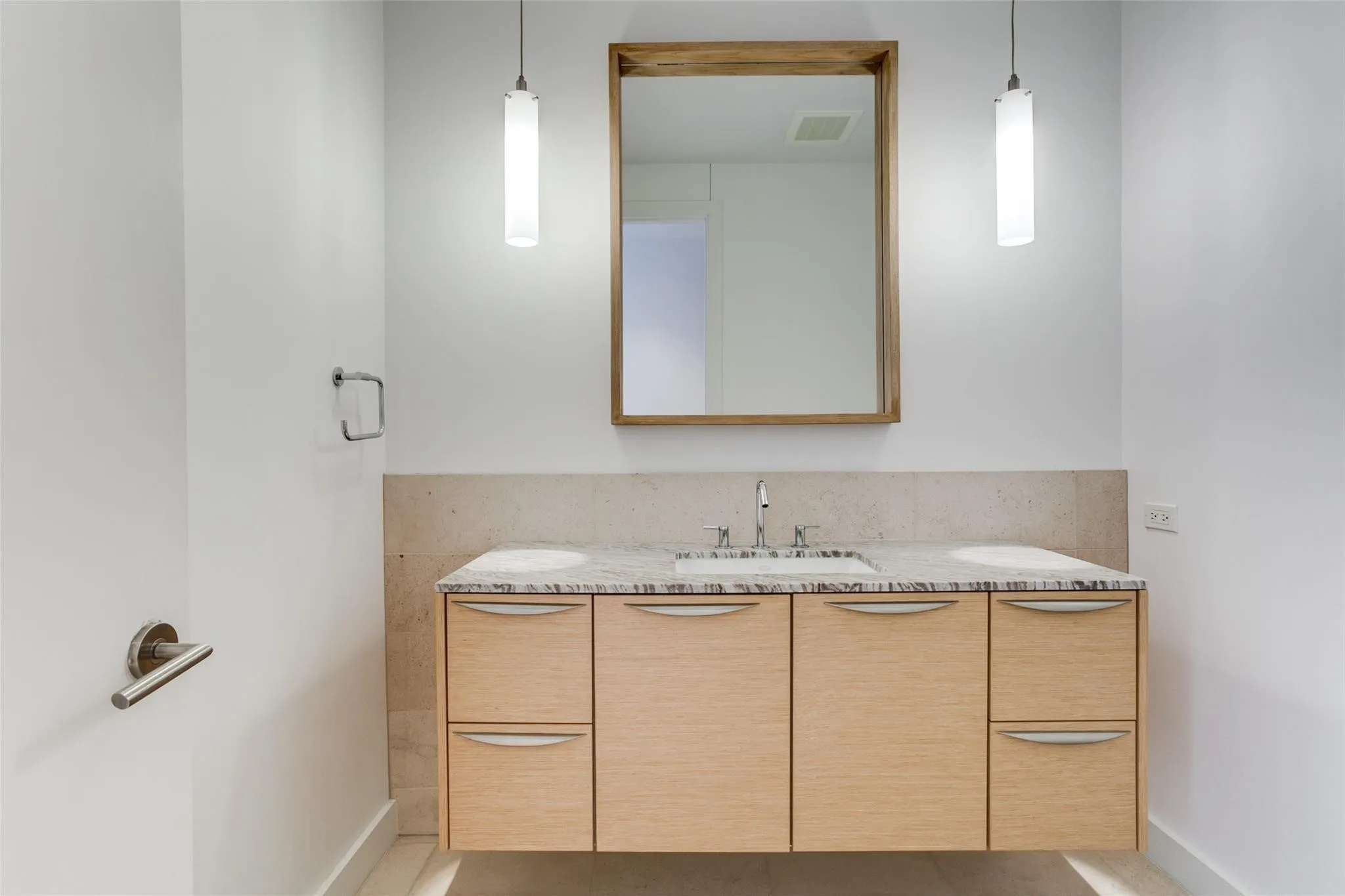 Floating wood-finish vanity with dual undermount sinks and a stone-finish countertop