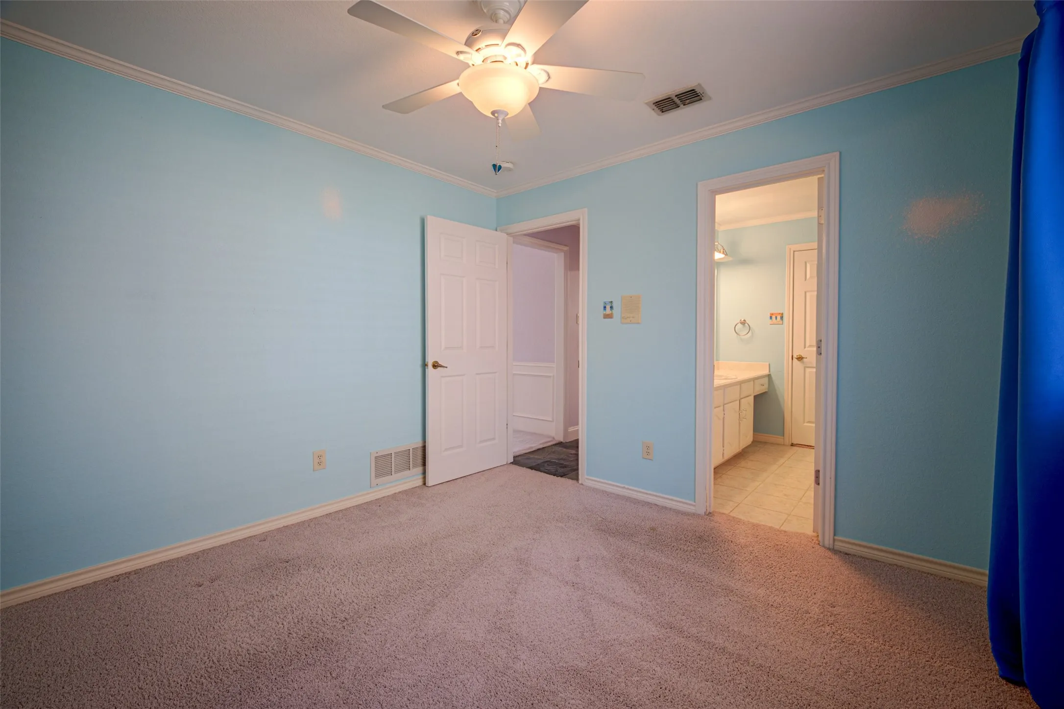 Carpeted room with crown molding and ceiling fan