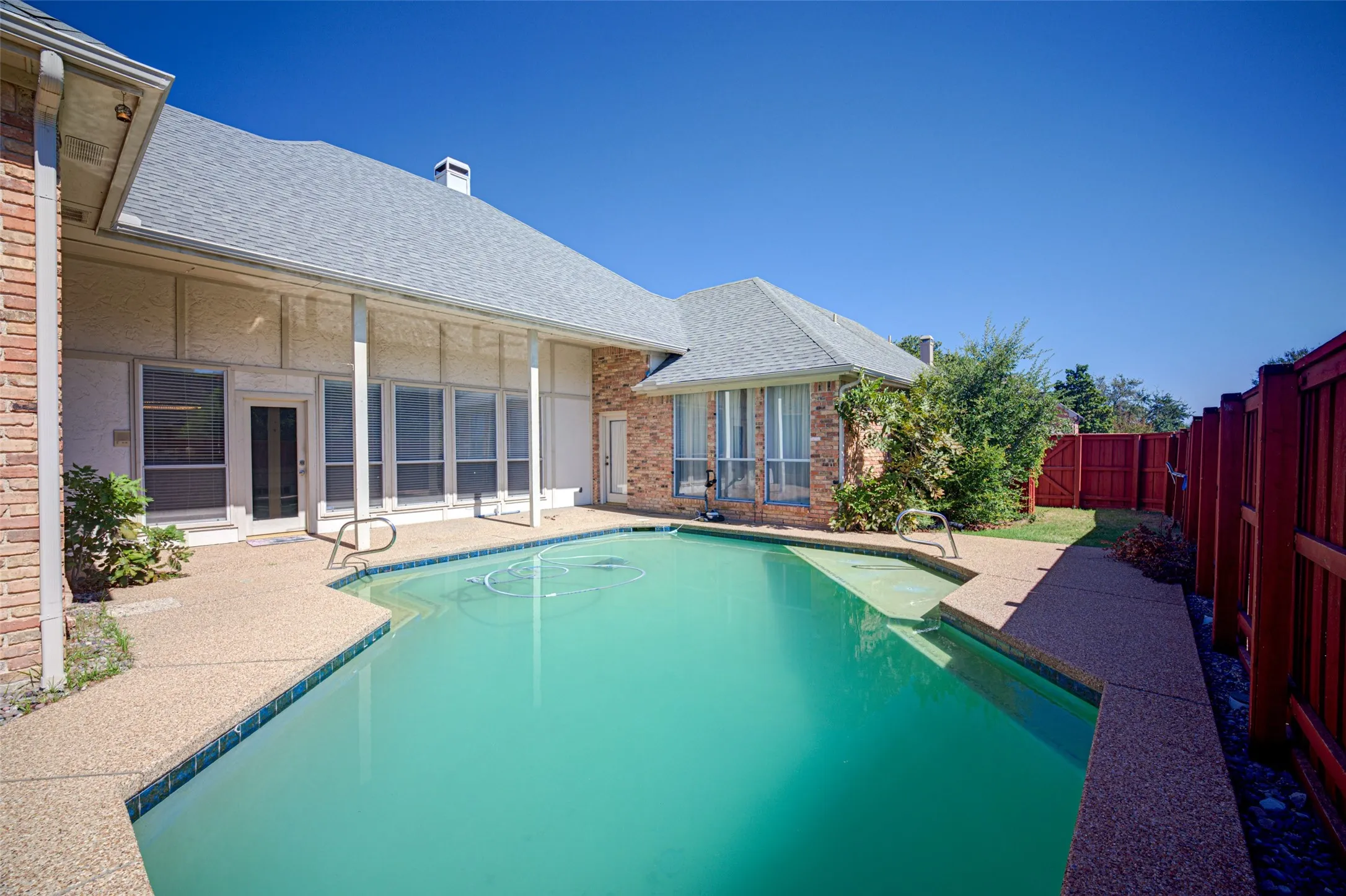 Private outdoor pool with a surrounding aggregate concrete patio