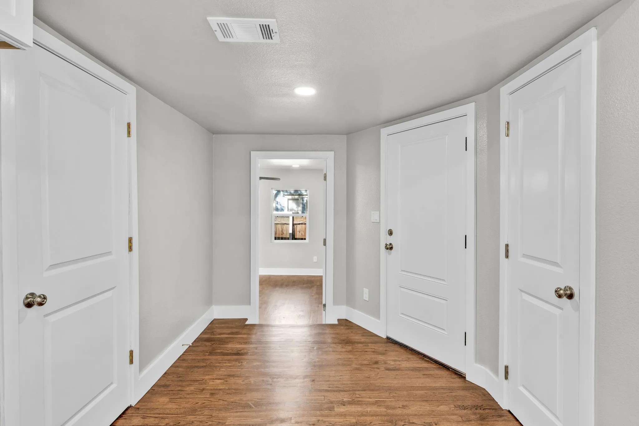 Wood-finish flooring with white trim and neutral wall tones