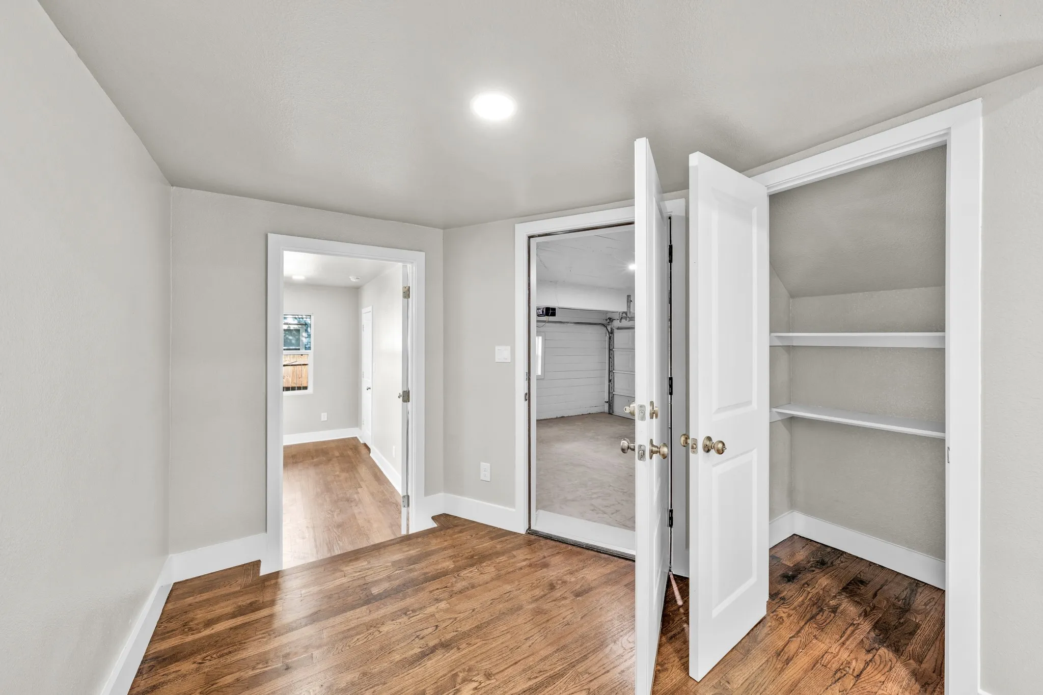 Hardwood-finish flooring, recessed lighting, white interior doors, and built-in closet shelving