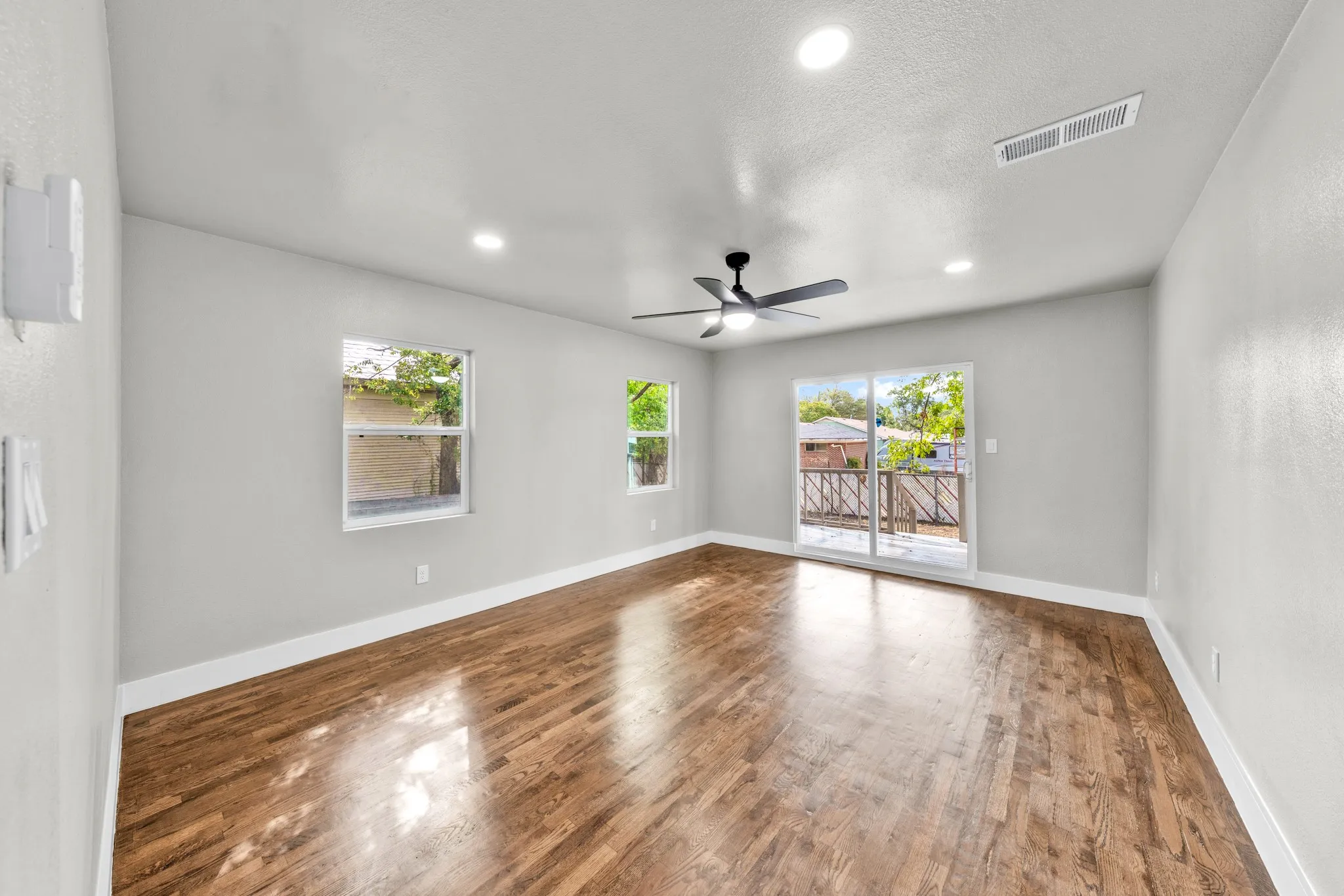 Wood-finish flooring, recessed lighting, and a ceiling fan