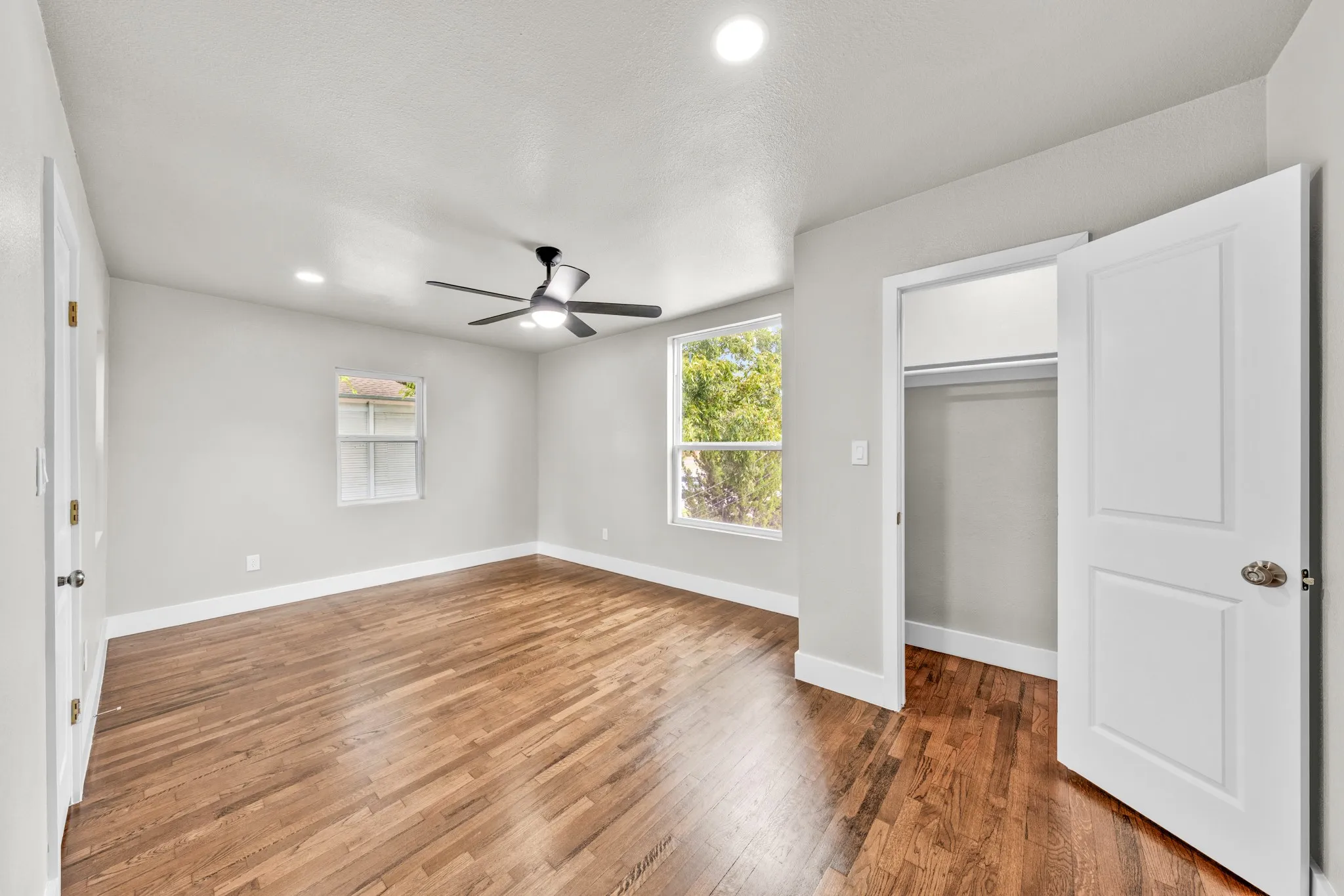 Hardwood flooring, recessed lighting, ceiling fan, white trim, and a built-in closet