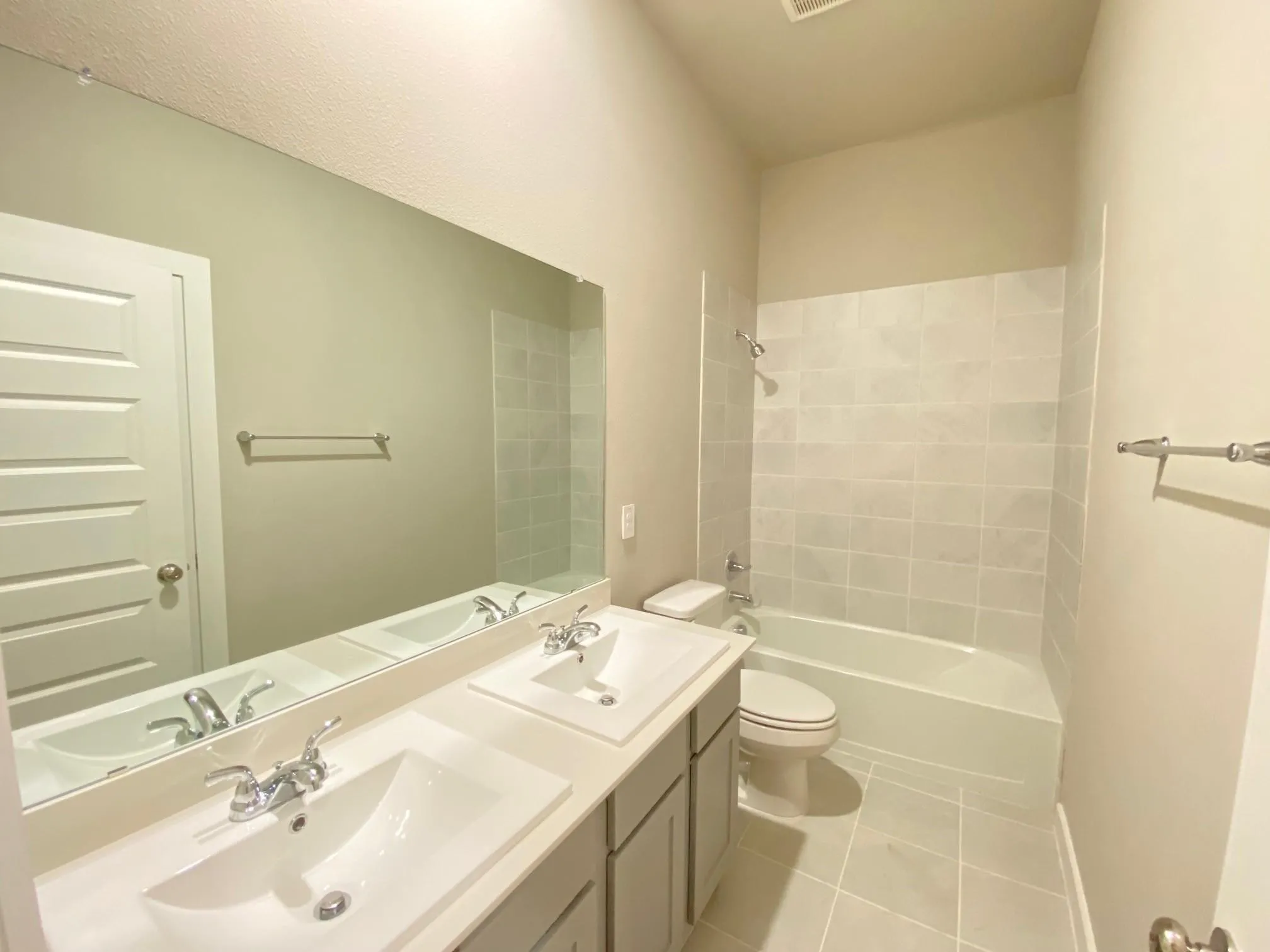 Dual vanity with undermount sinks, chrome fixtures, and a spacious mirror
