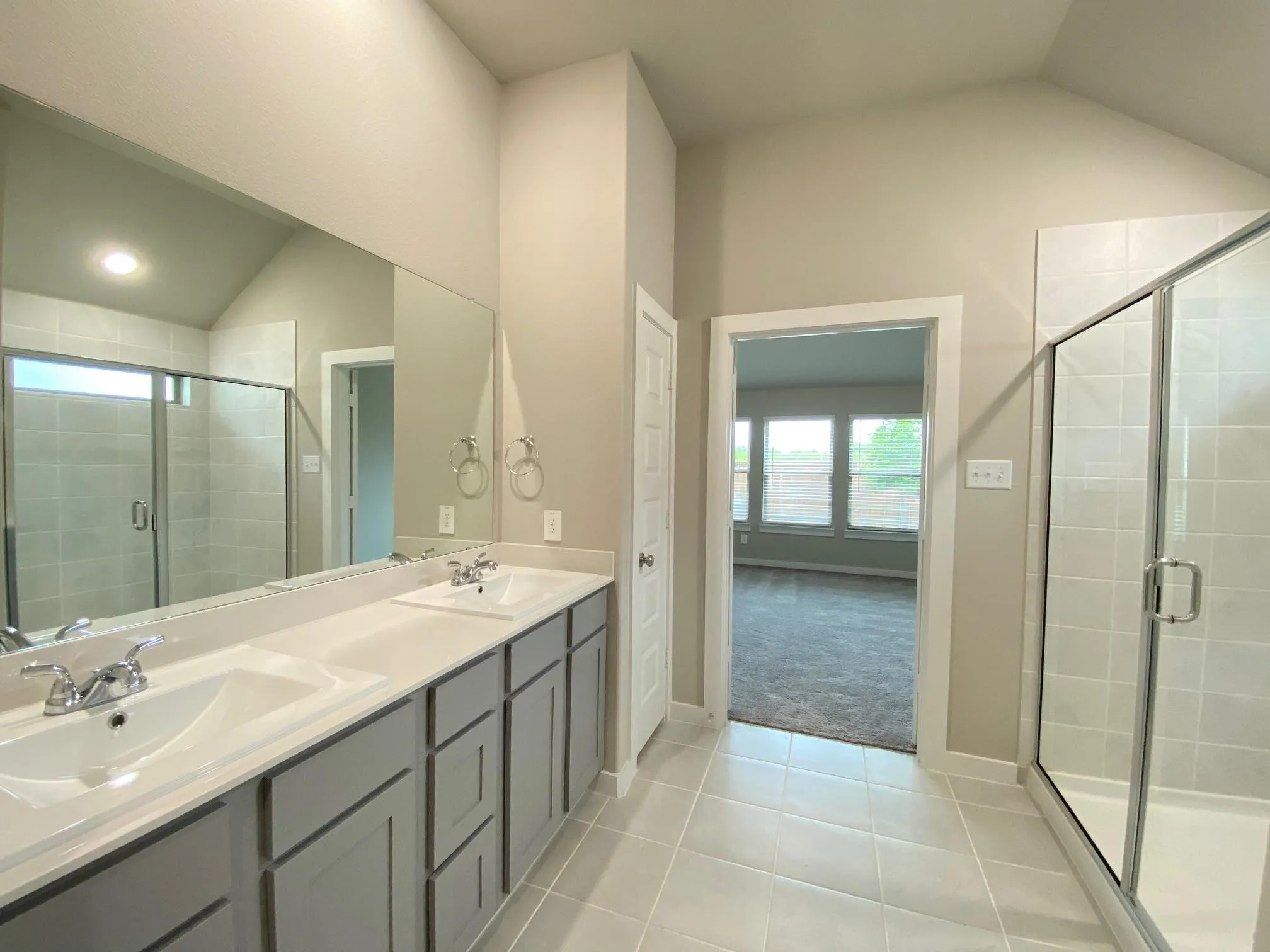 Dual vanity with integrated sinks, framed mirrors, and gray cabinetry