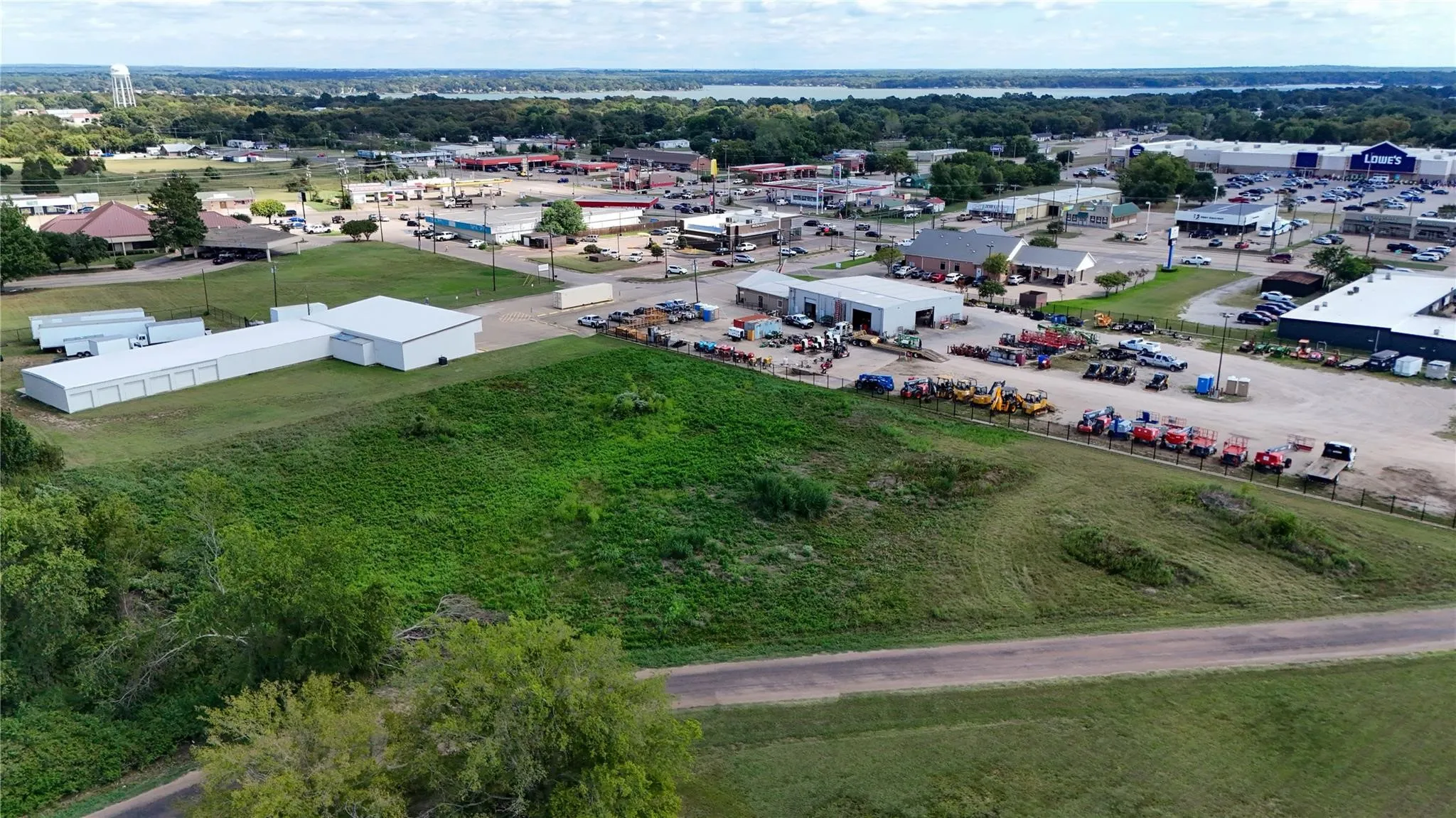Expansive commercial lot featuring a large open field and paved road access
