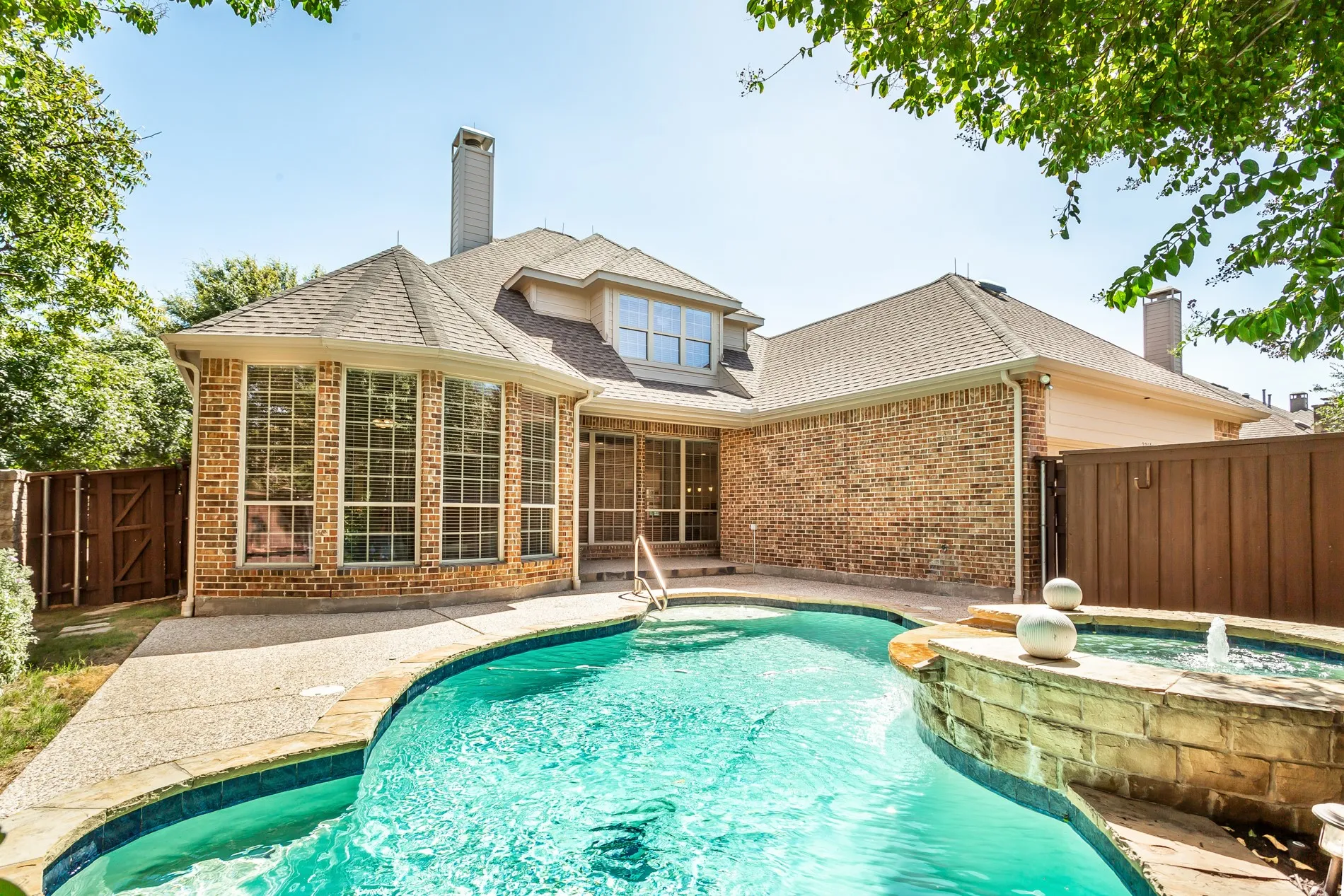 Brick exterior with multi-pane windows and a shingled roof