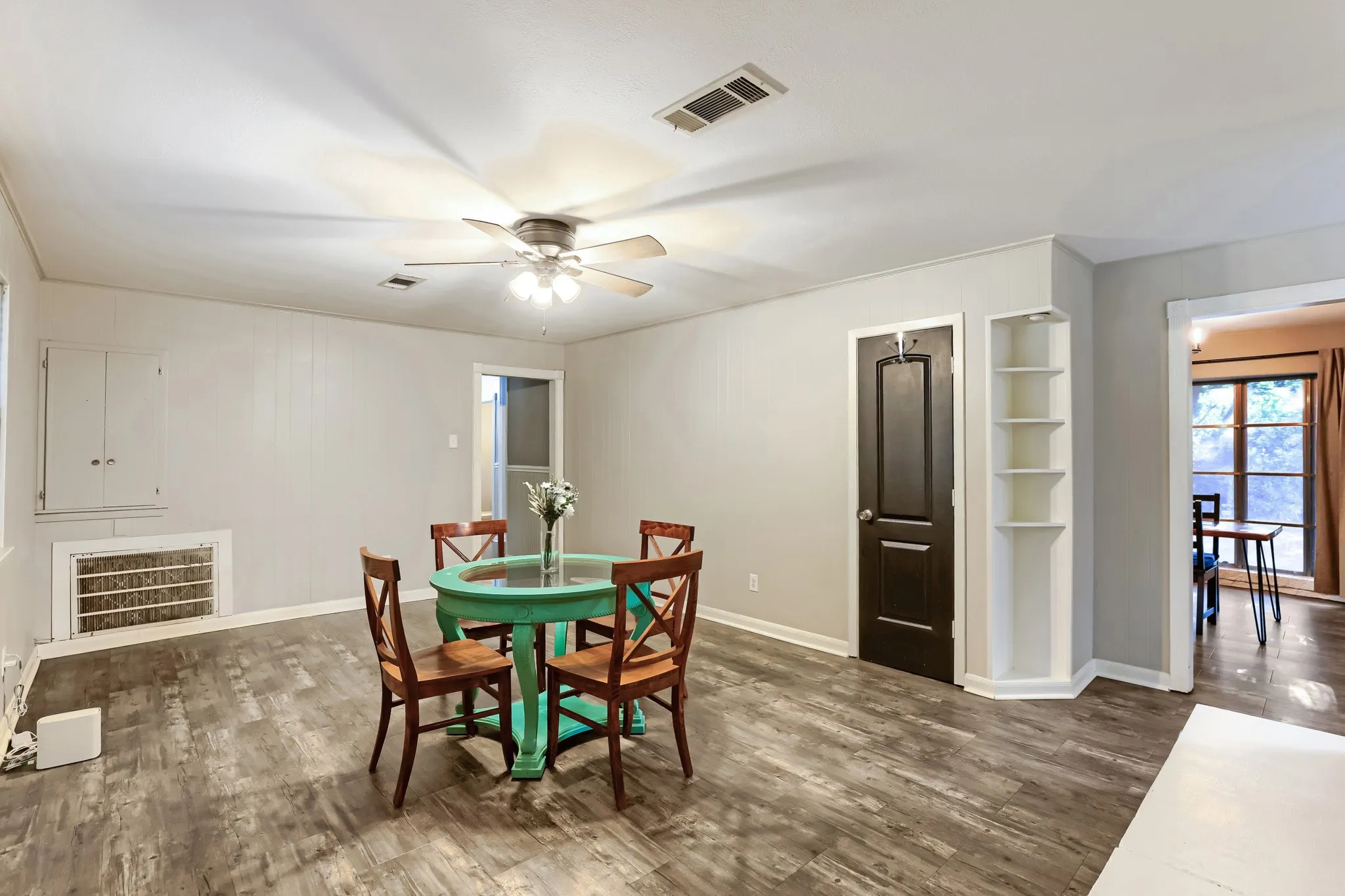 Wood-finish flooring throughout, complemented by a ceiling fan with integrated lighting