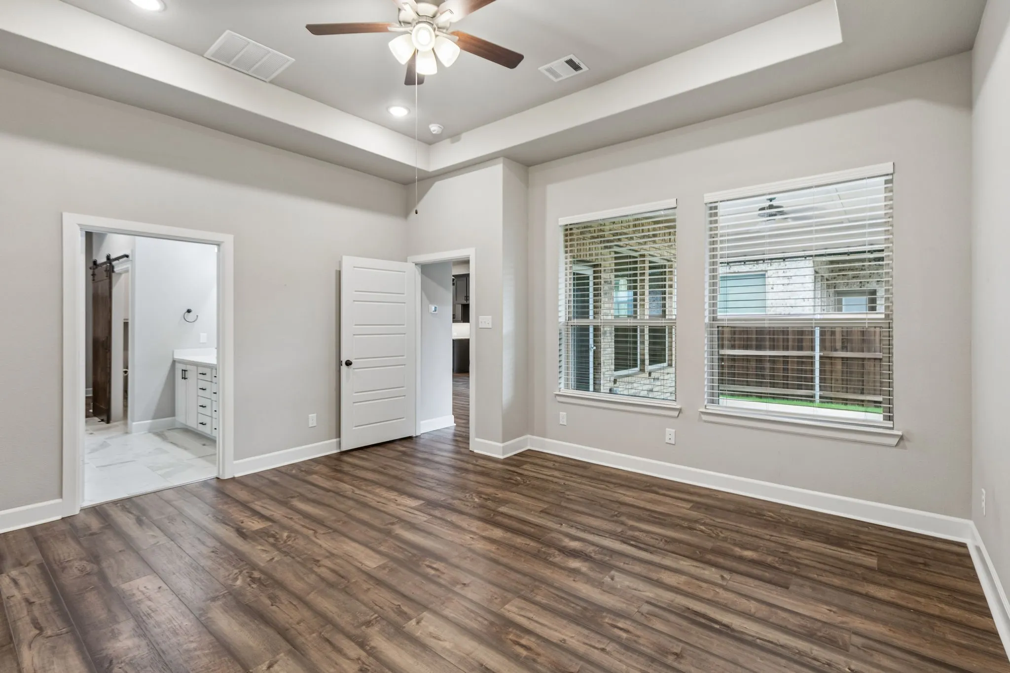 Wood-finish flooring with tray ceiling and recessed lighting