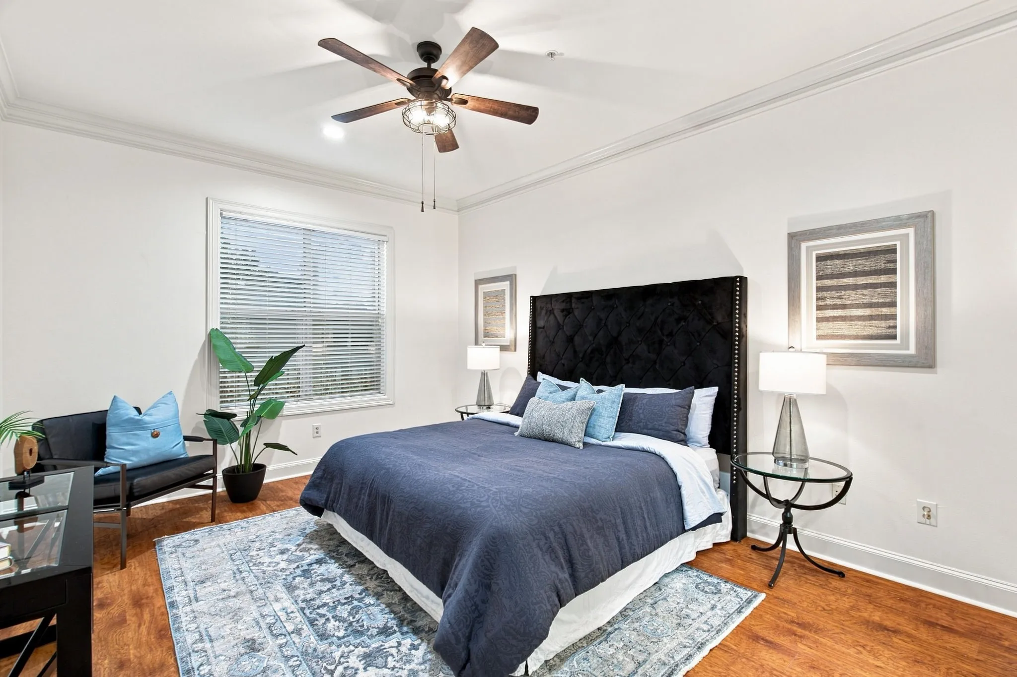 Primary bedroom with ensuite, wood-finish flooring, crown molding, and a ceiling fan with integrated lighting