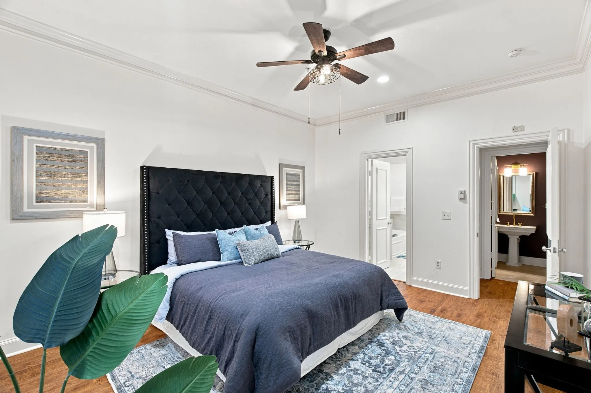 Hardwood-finish flooring, crown molding, and a ceiling fan with light fixture