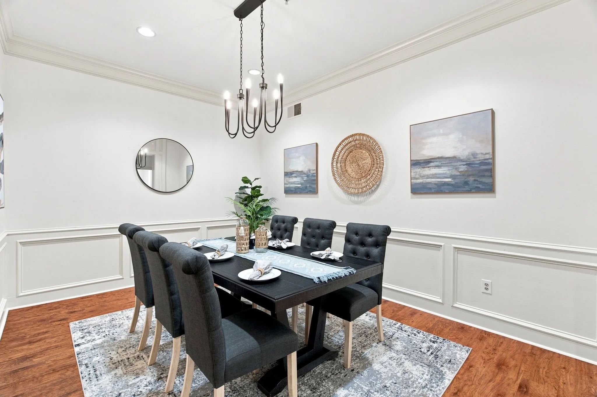 Crown molding and wainscoting paneling complement the wood-finish flooring