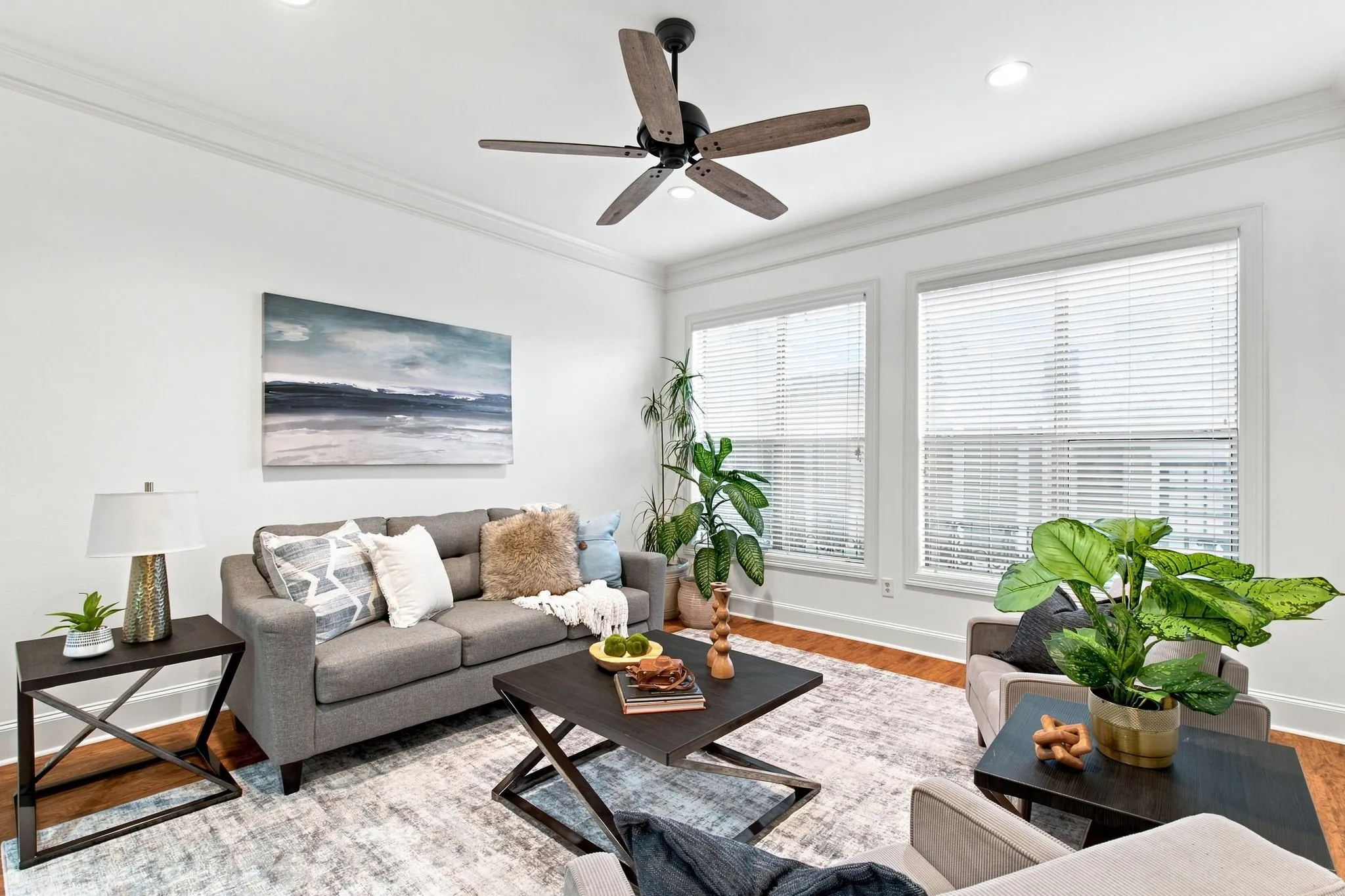 Recessed lighting, crown molding, wood-finish flooring, multiple windows, and a ceiling fan with integrated lighting