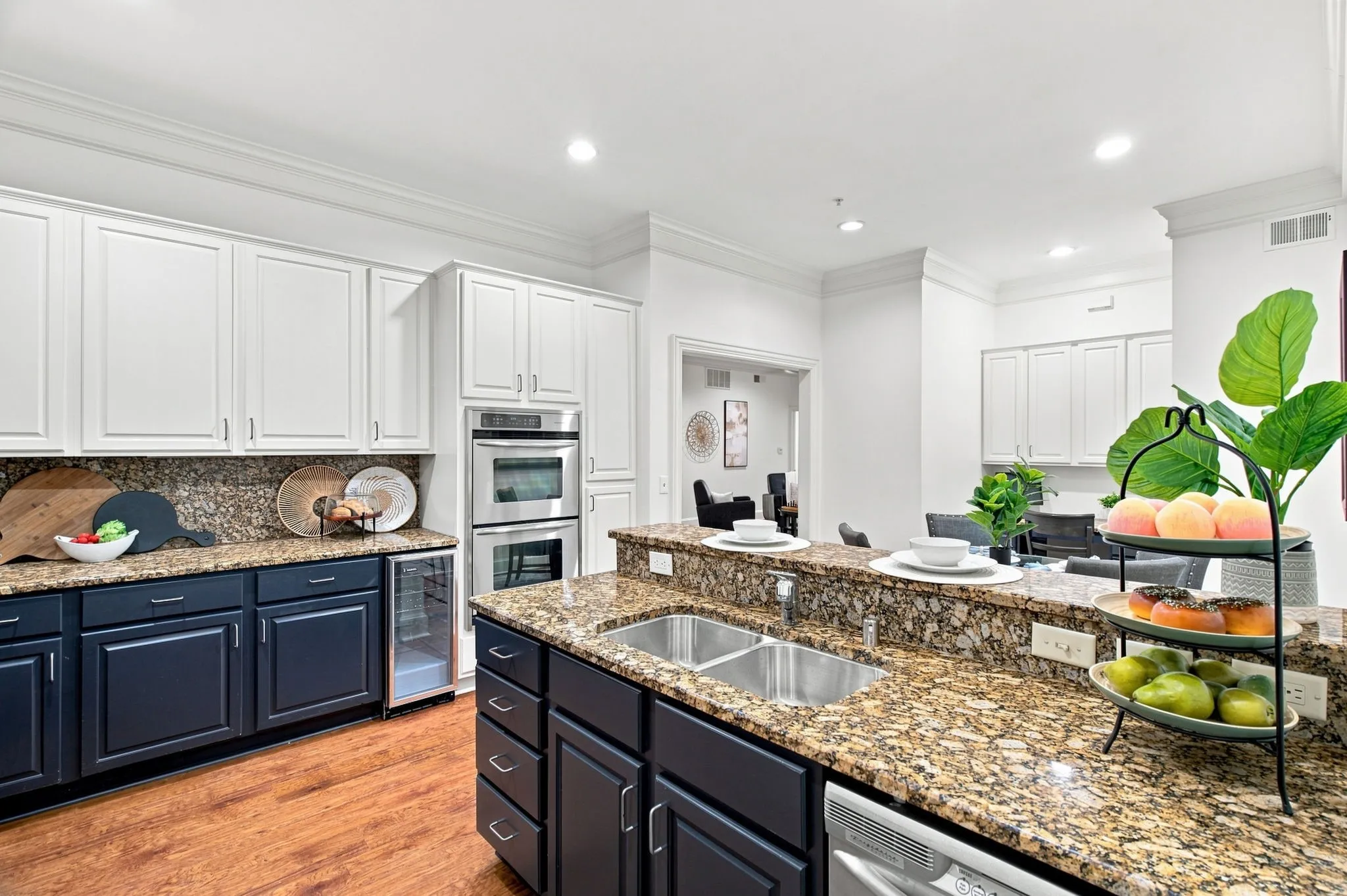 Kitchen featuring granite countertops, stainless steel double wall ovens, a dual basin stainless steel sink, and wood-finish flooring
