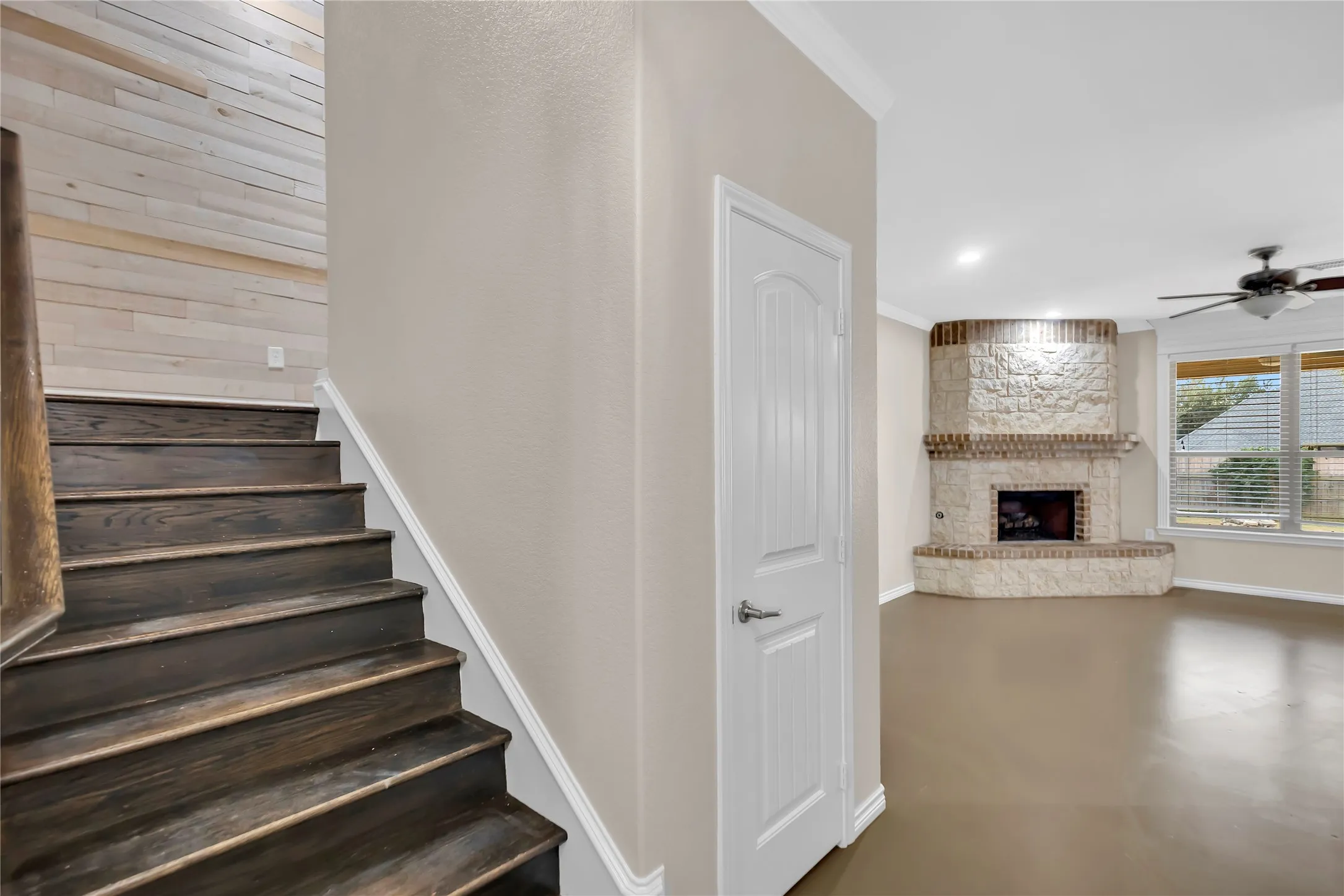 Dark wood-finish stairs with a shiplap accent wall