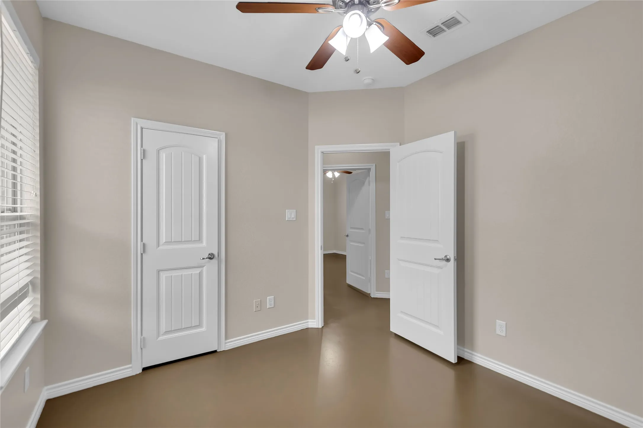 Vaulted ceiling with a ceiling fan, neutral wall tones, wood-finish flooring, and white trim