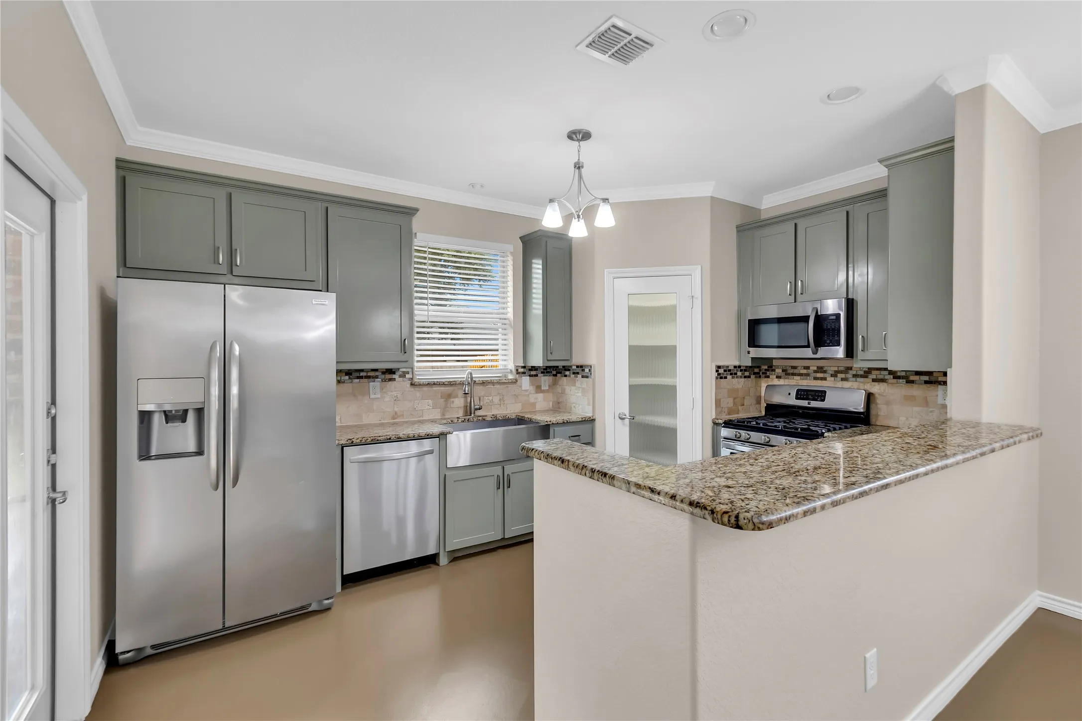 Kitchen featuring gray cabinetry, stainless steel appliances, a farmhouse sink, and granite countertops