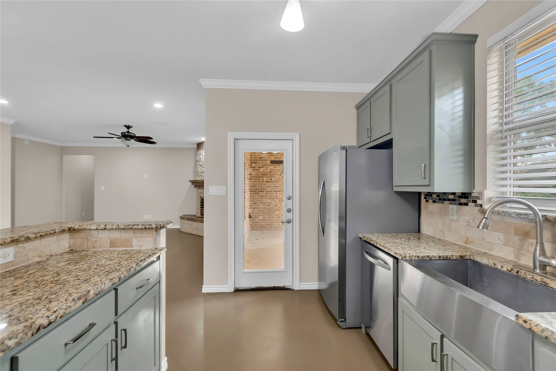 Kitchen featuring light-colored cabinetry, granite countertops, stainless steel appliances, and a mosaic tile backsplash