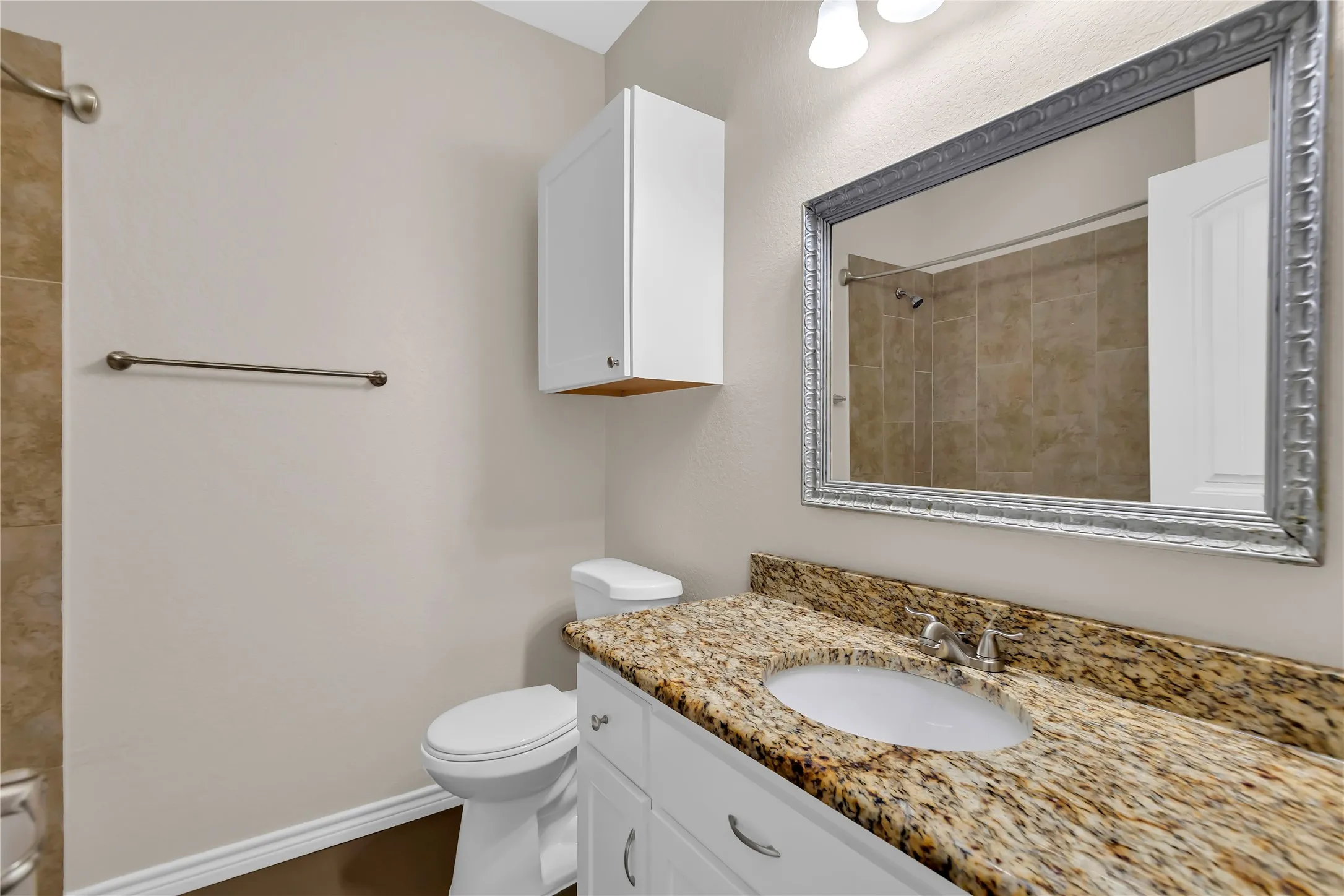 Vanity with a granite countertop, undermount sink, and chrome faucet
