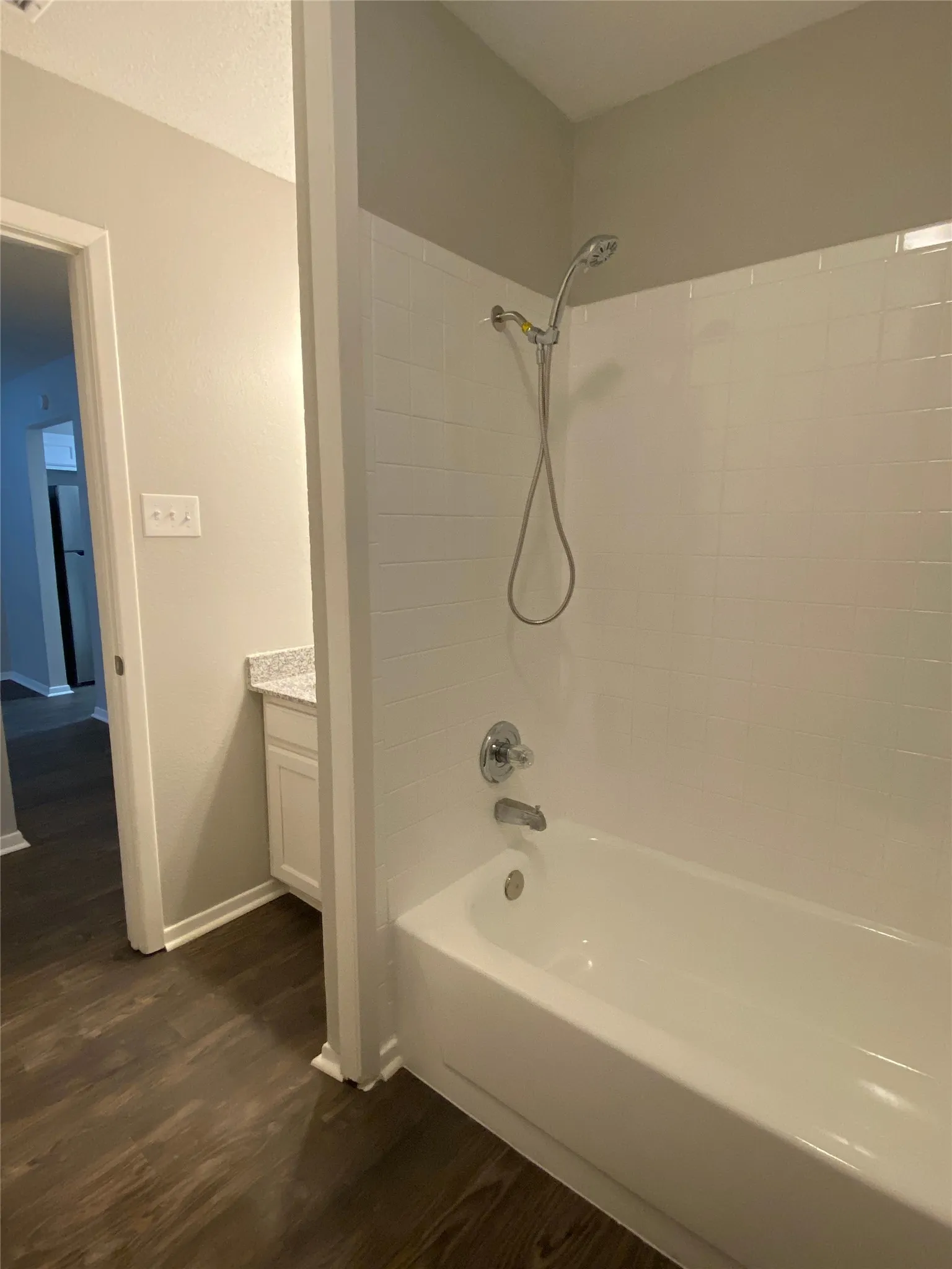 Tub and shower combination featuring a chrome showerhead and faucet