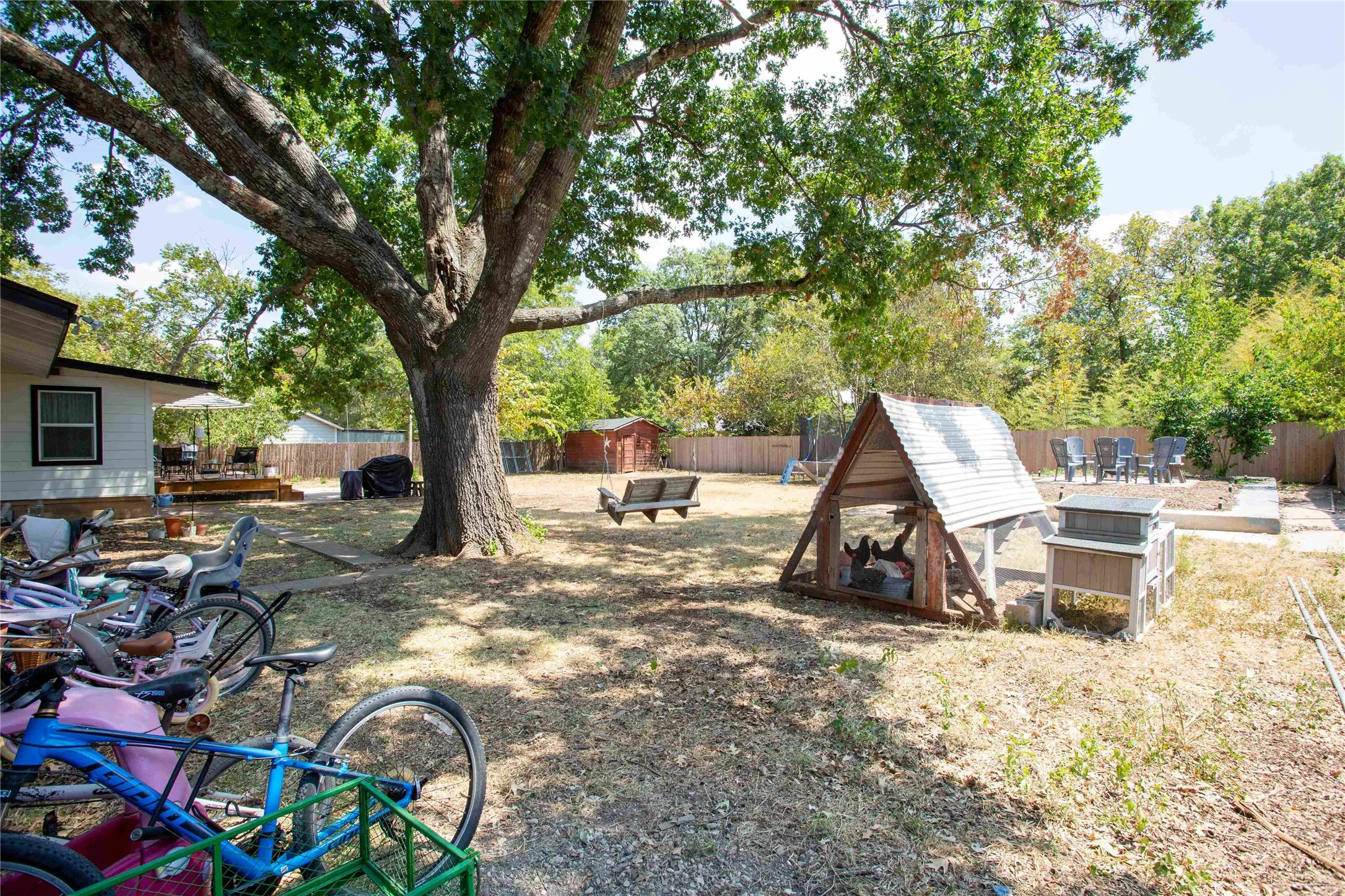 Expansive backyard featuring a mature shade tree, a raised deck, and a privacy​​‌​​​​‌​​‌‌​‌‌​​​‌‌​‌​‌​‌​​​‌​​ fence