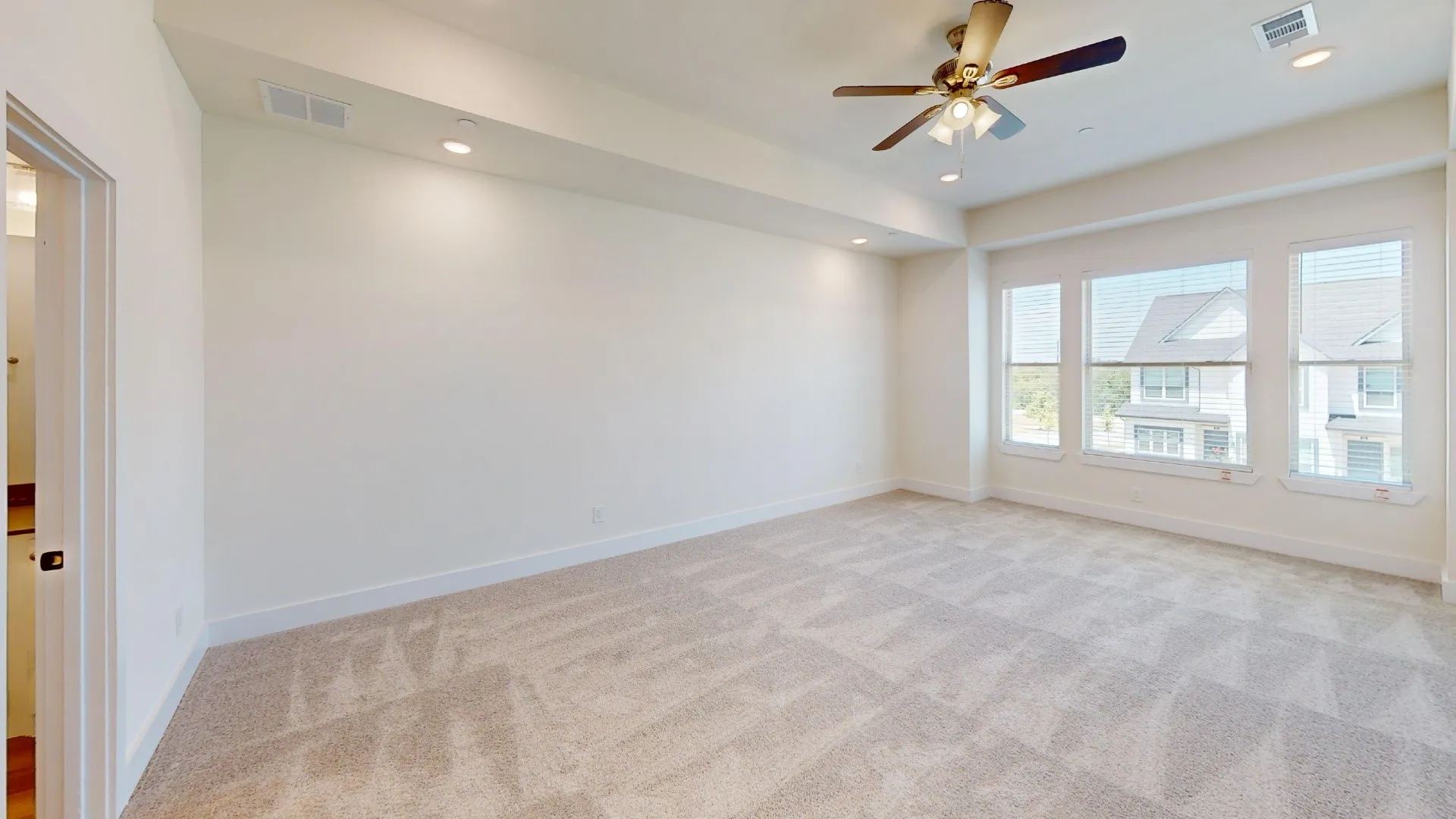 Recessed lighting, ceiling fan, triple windows with blinds, and neutral carpeting