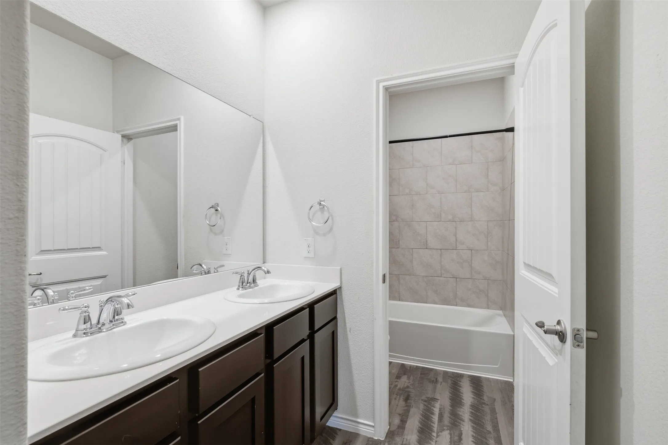 Upstairs Bathroom with dual sinks and a bathtub/shower combo