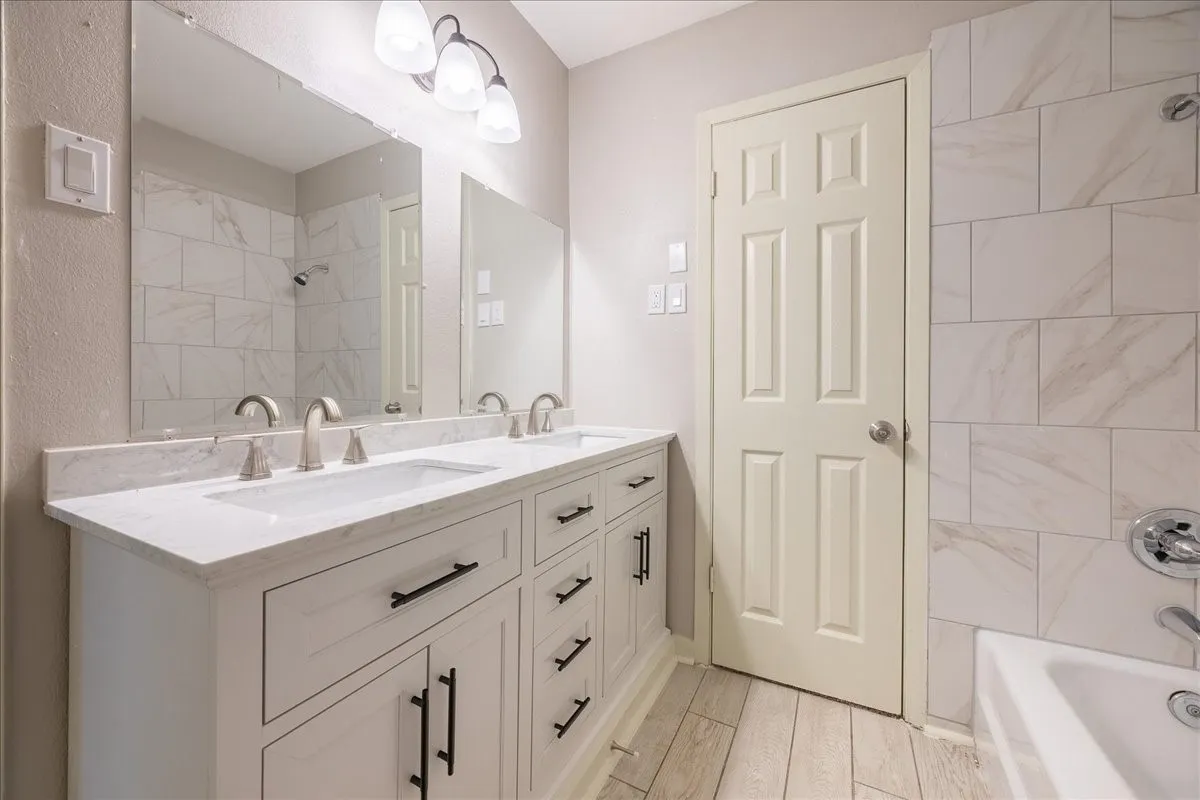 Dual vanity with undermount sinks, stone-finish countertop, and brushed nickel fixtures