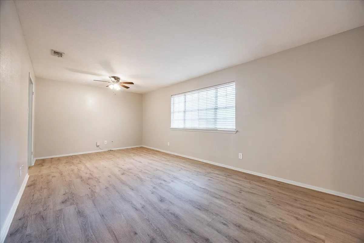 Spacious interior with wood-finish flooring and neutral wall tones