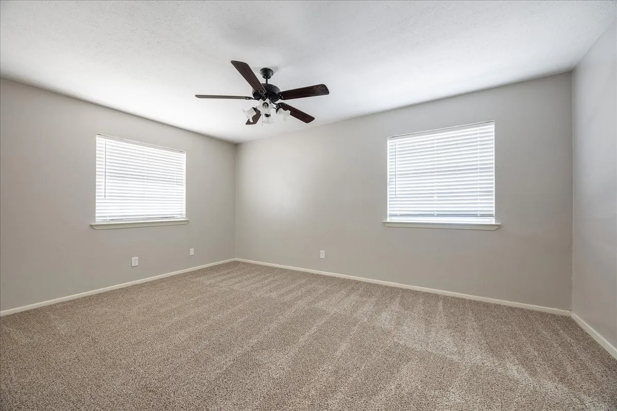 Spacious room featuring neutral carpeting and light gray walls