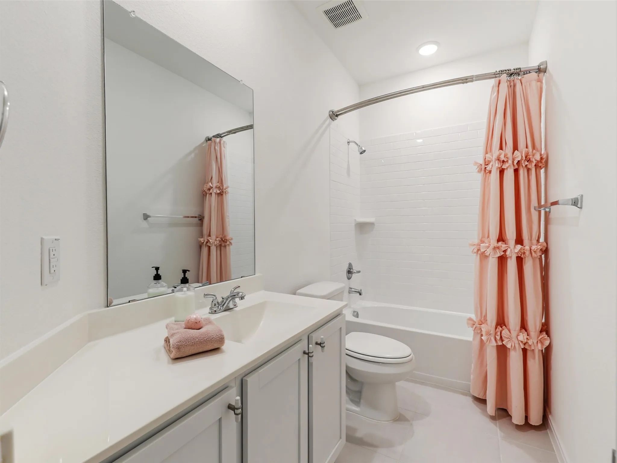 Bathroom featuring a built-in vanity with light-toned countertop, undermount sink, and chrome fixtures