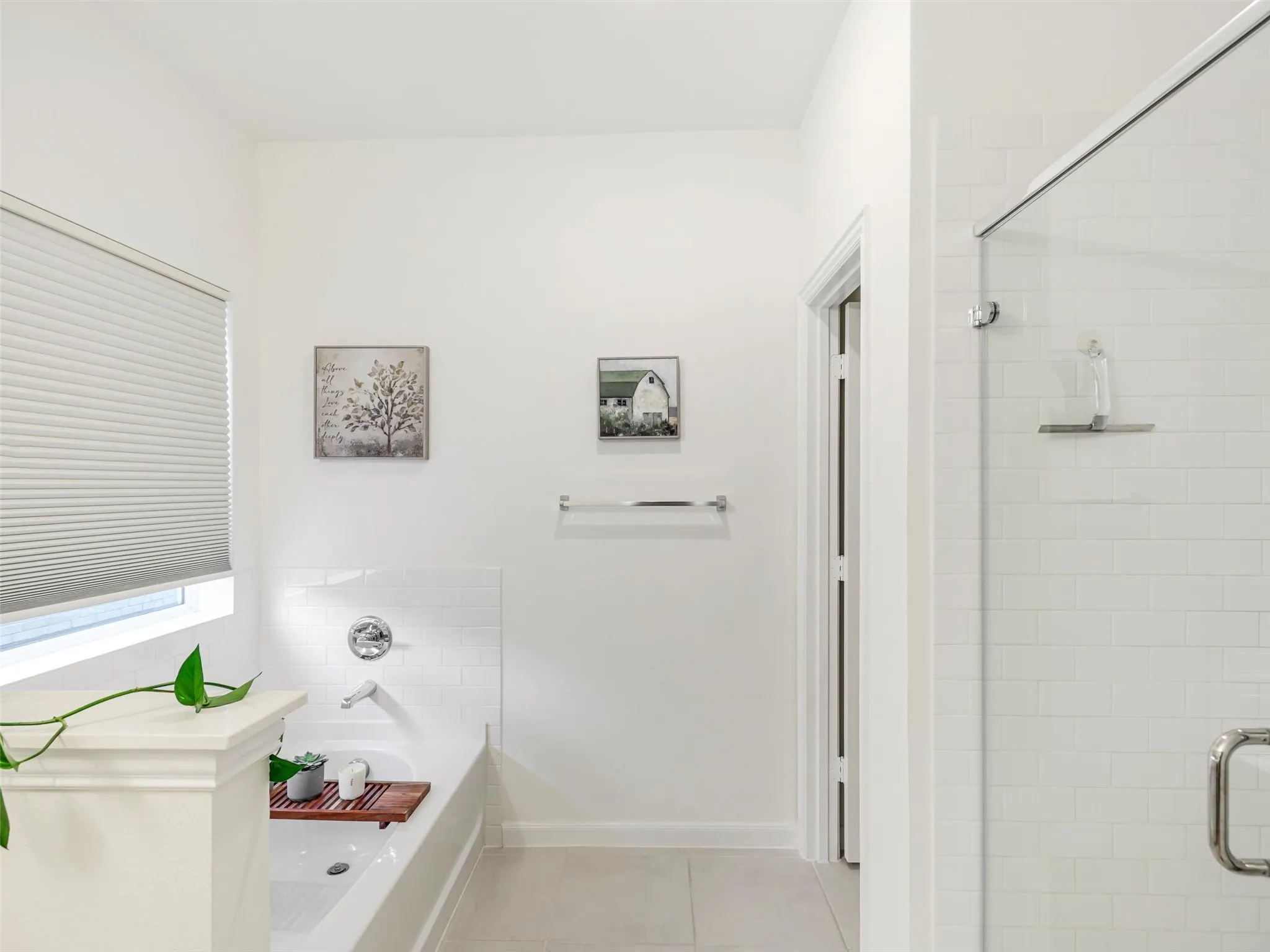 White subway tile shower surround with clear glass enclosure and chrome hardware