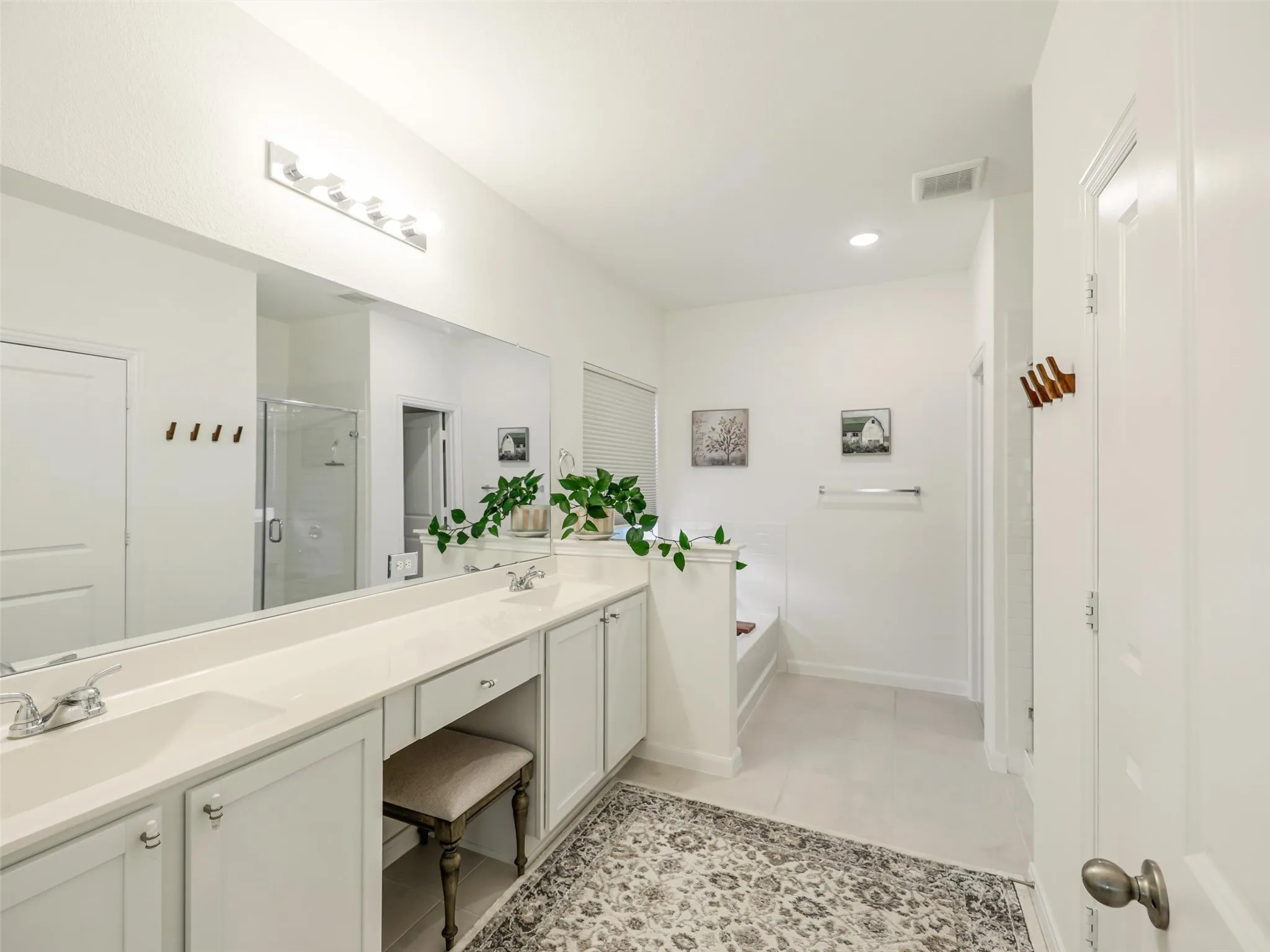Dual vanity with integrated sinks, expansive counter space, recessed lighting, tile flooring, and built-in tub