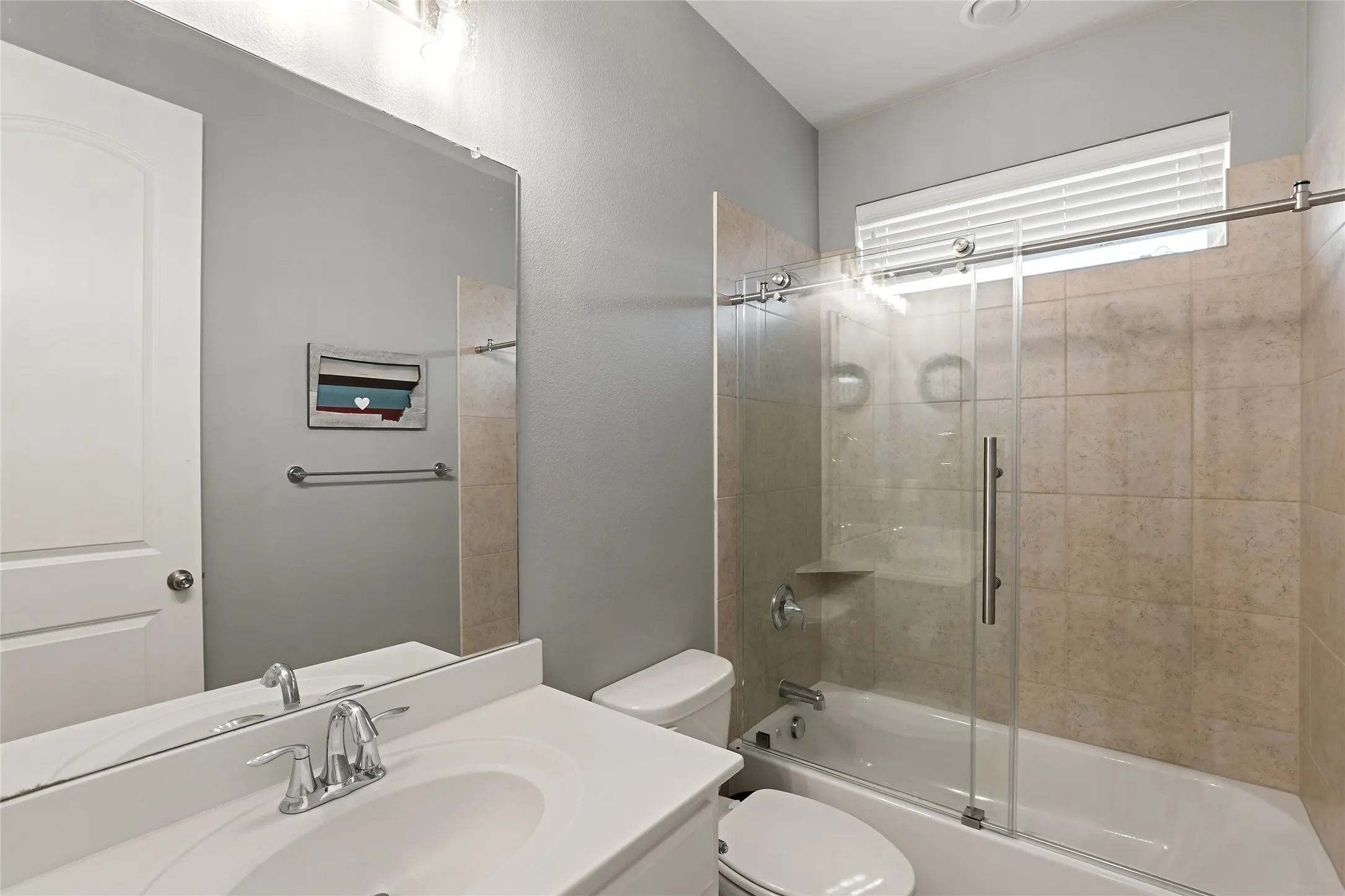 Vanity with integrated sink, chrome faucet, and expansive mirror