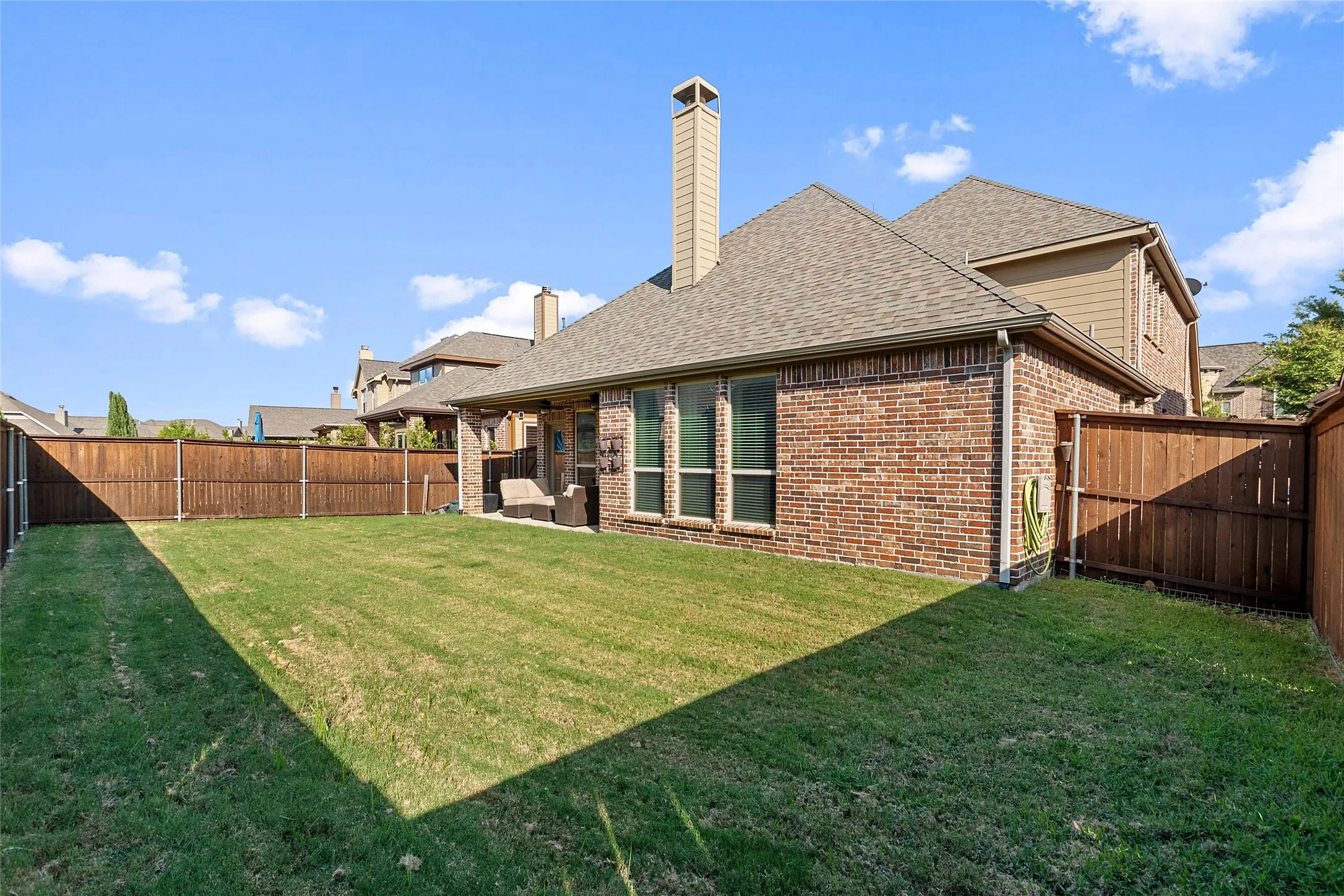 Expansive lawn area with a wood-fenced perimeter