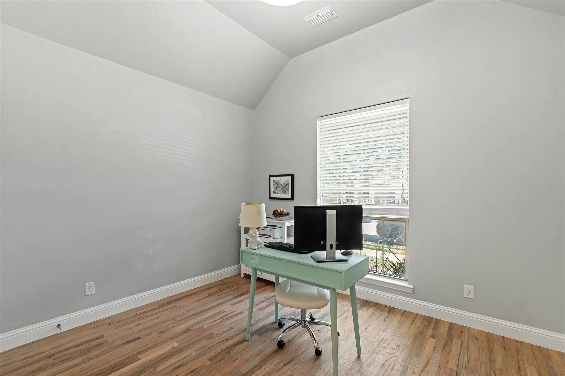 Vaulted ceiling, wood-finish flooring, recessed lighting, and a large window with blinds