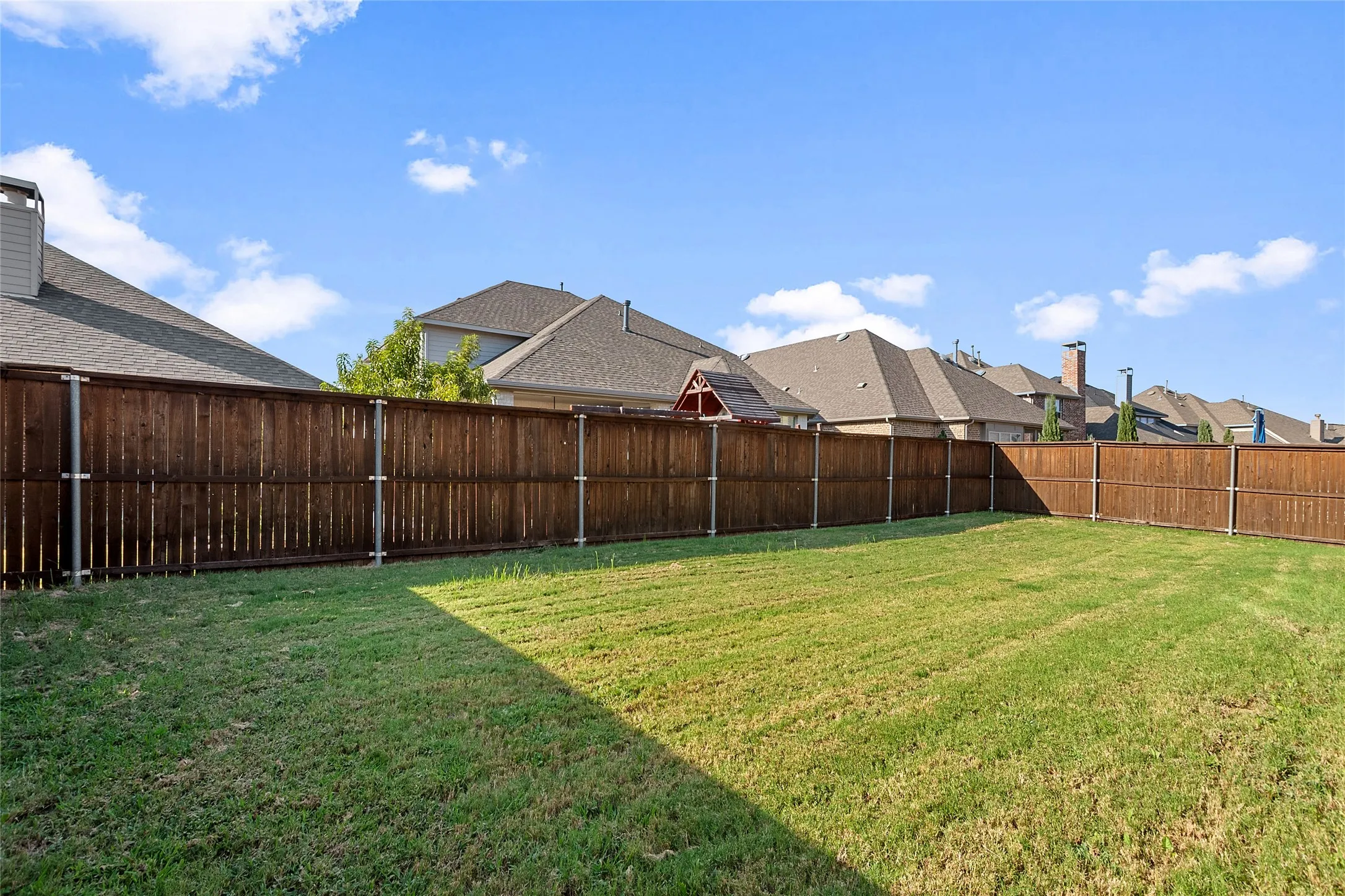 Expansive backyard with a full perimeter wood fence
