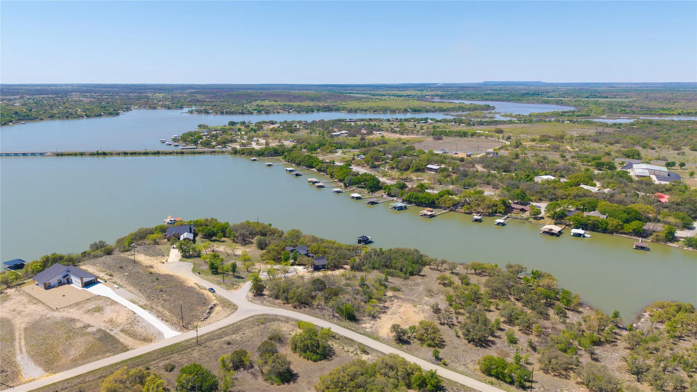 Expansive waterfront property featuring a newly constructed residence, direct lake access, and a private driveway