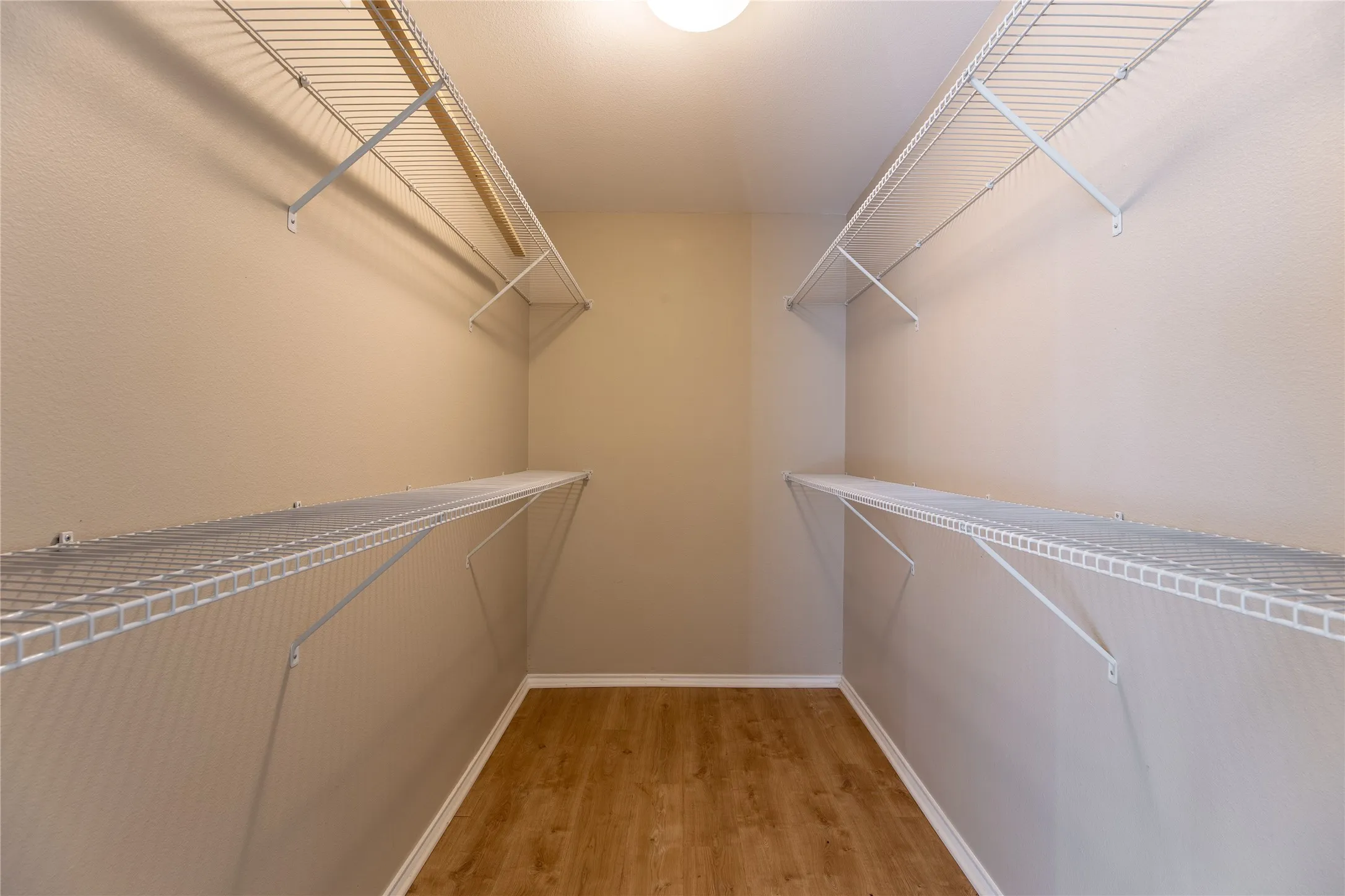 Recessed ceiling light, wood-finish flooring, and wire shelving