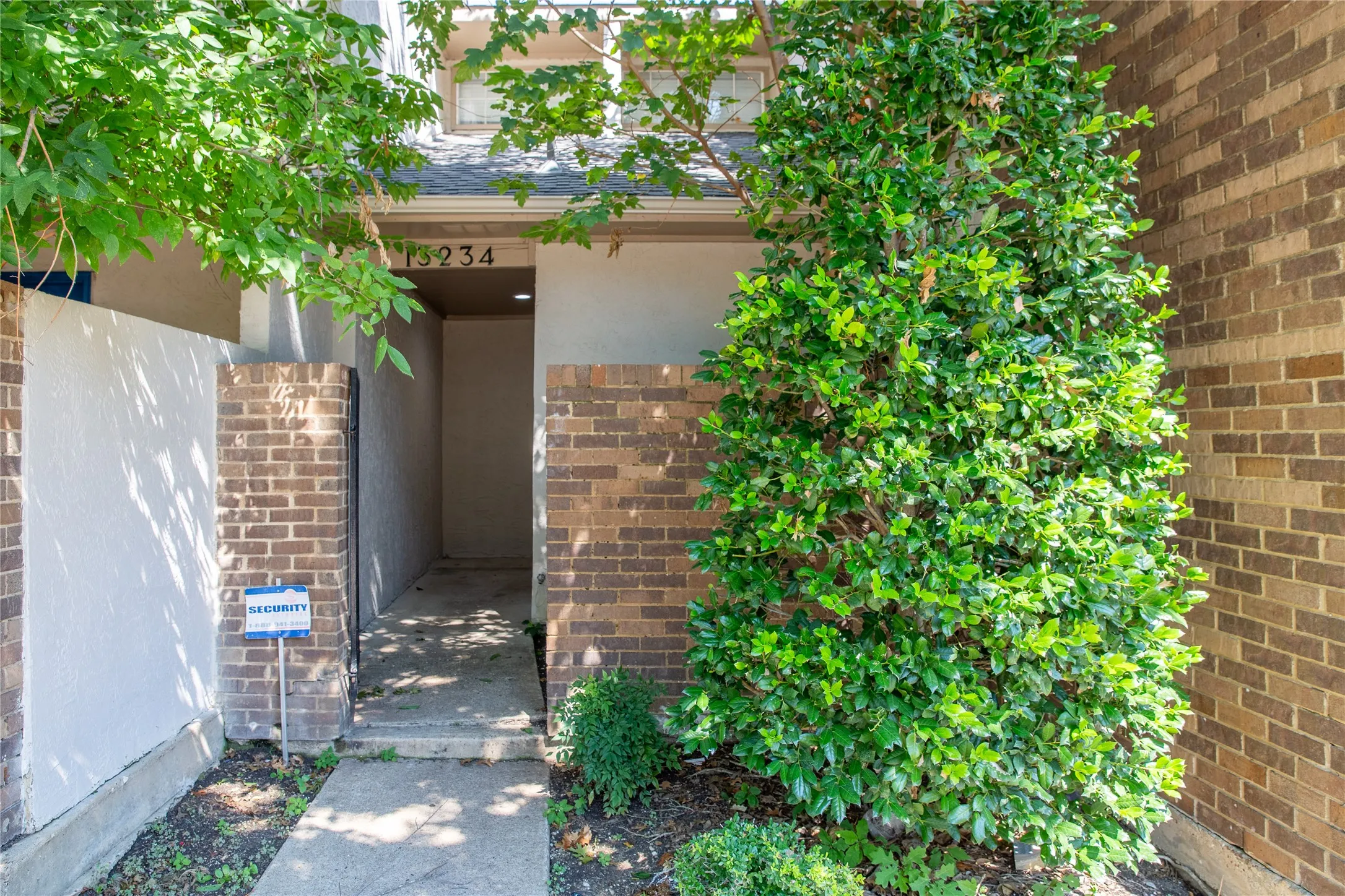 Brick exterior with a covered entry and concrete walkway