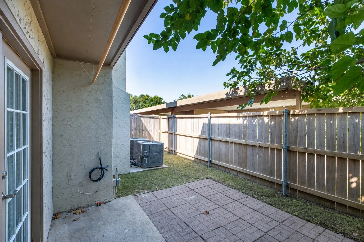 Patio area featuring brick pavers and a privacy fence
