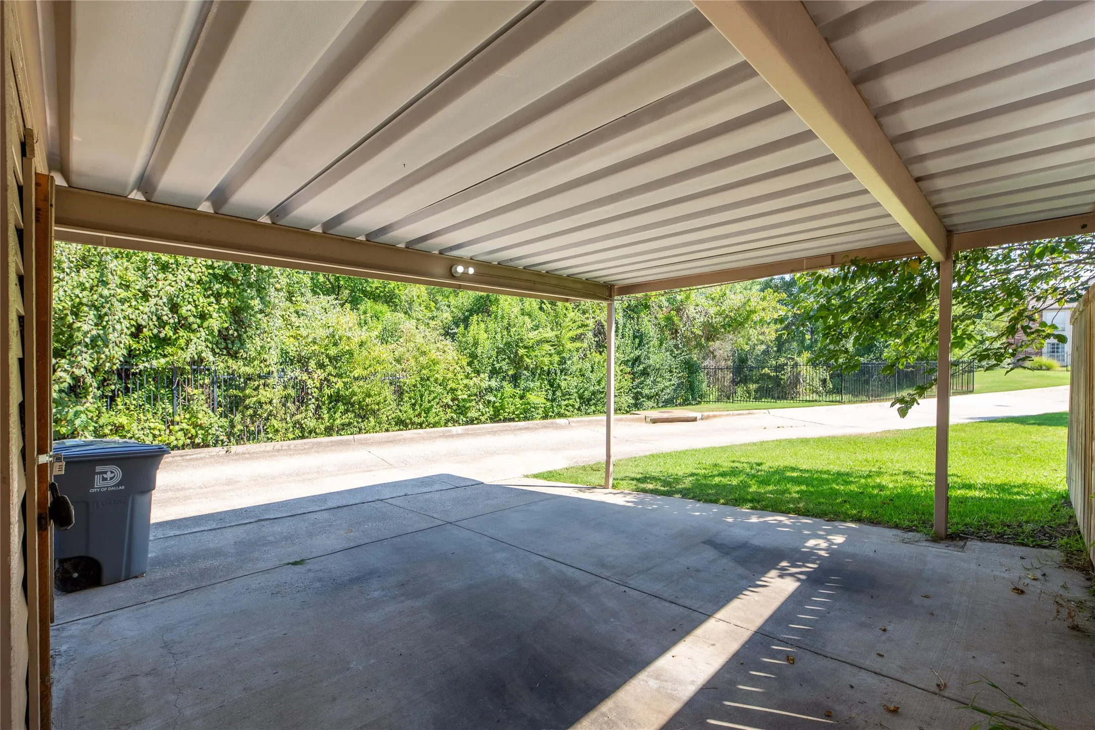 Covered carport with concrete flooring and integrated lighting