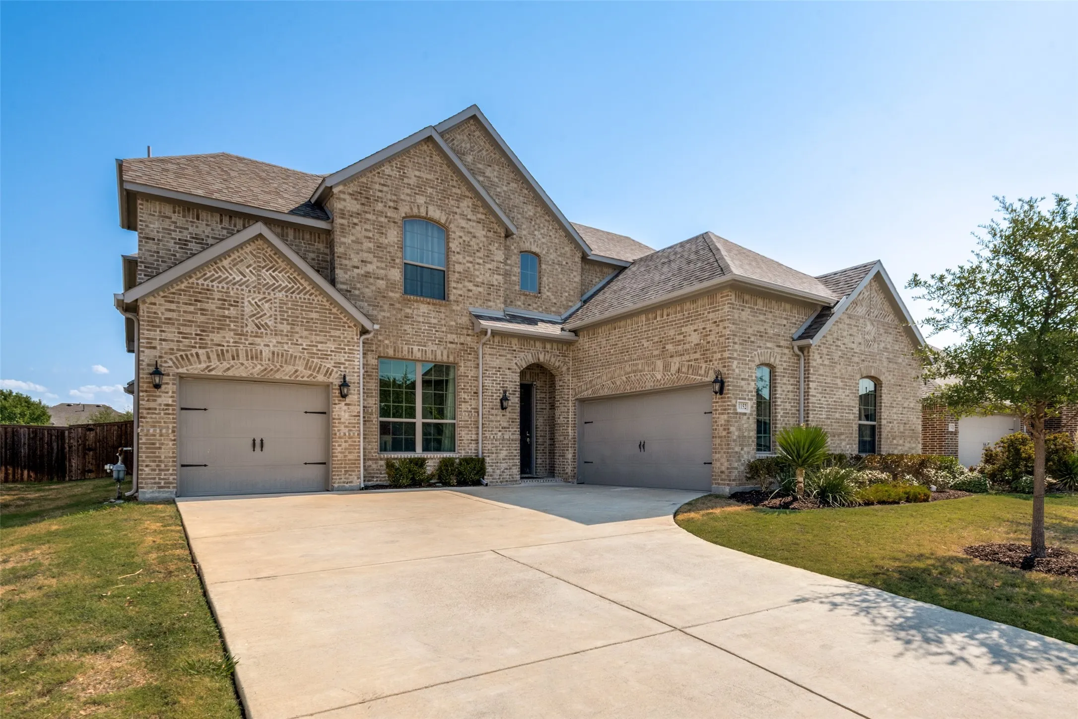 Brick exterior with multiple gables, two-car garage, and an additional single-car garage