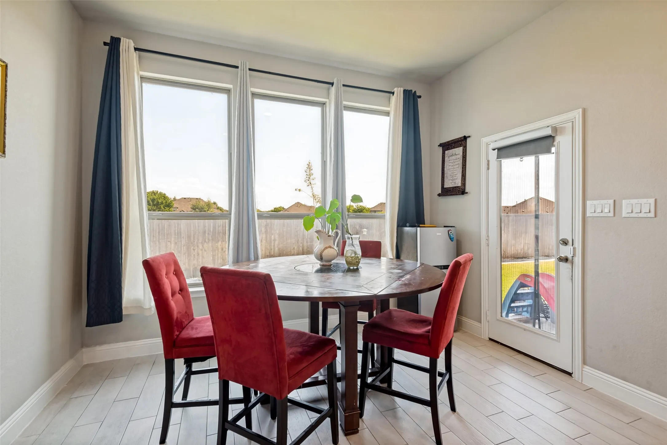 Vertical pane windows, full-lite glass door, and light wood-finish flooring