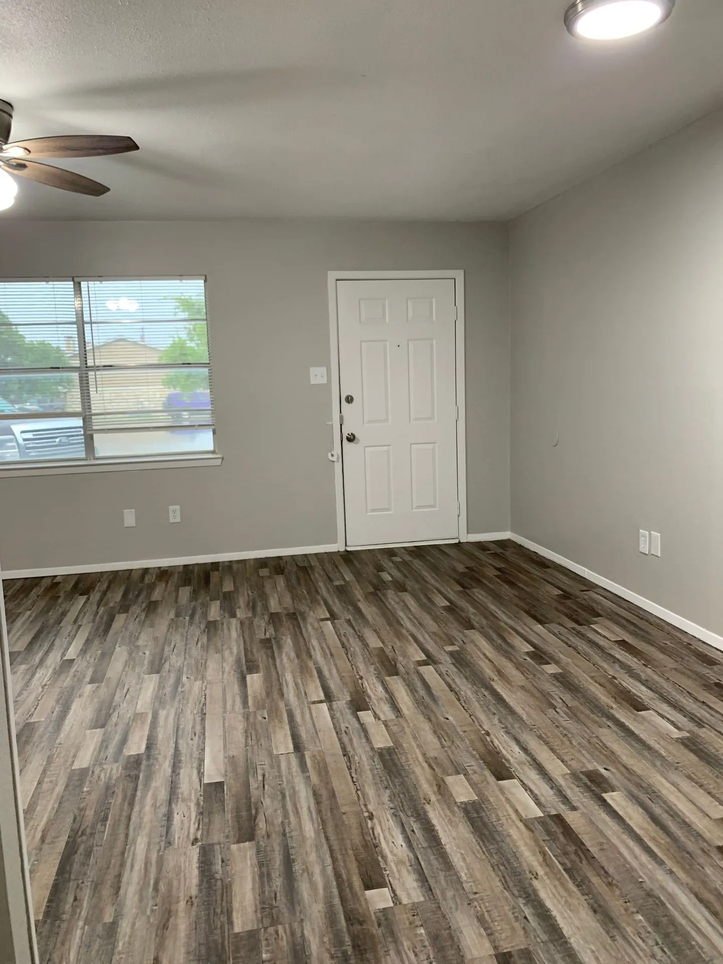 Wood-finish flooring throughout, recessed ceiling lighting, ceiling fan, and a paneled entry door