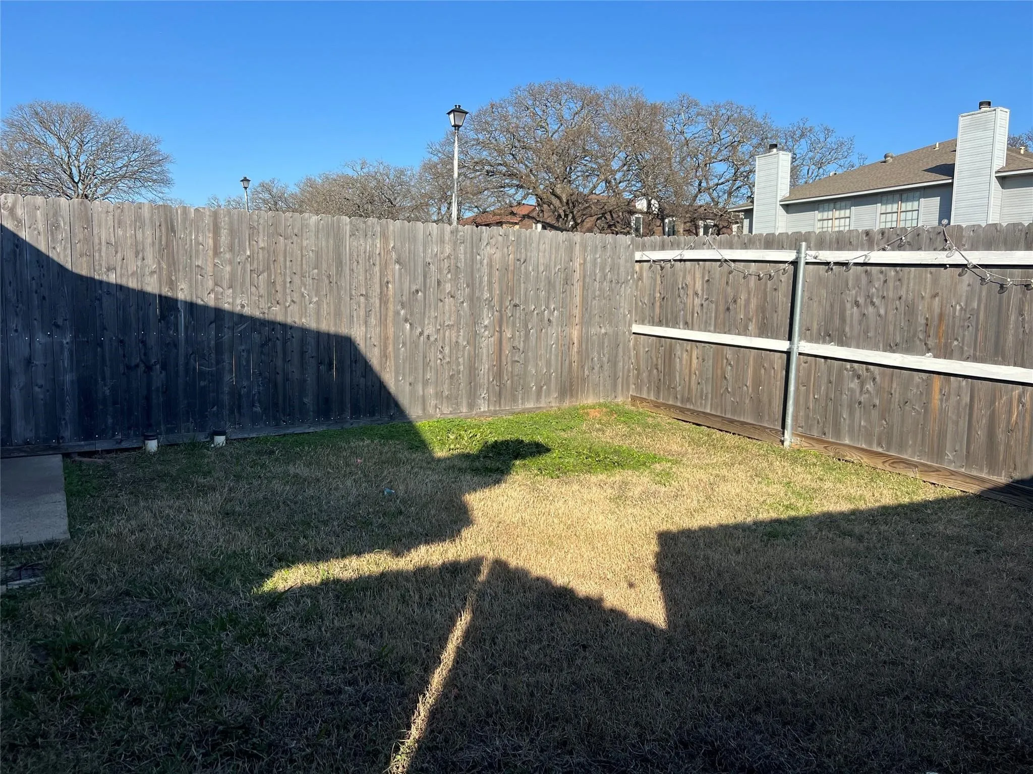 Enclosed backyard featuring wood fencing and a grassy area