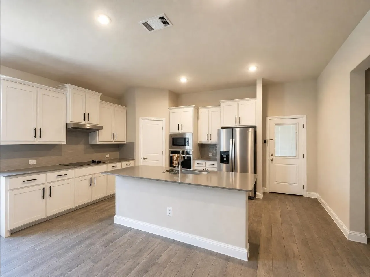 Kitchen featuring white cabinetry, stainless steel appliances, a center island, recessed lighting, and wood-finish flooring